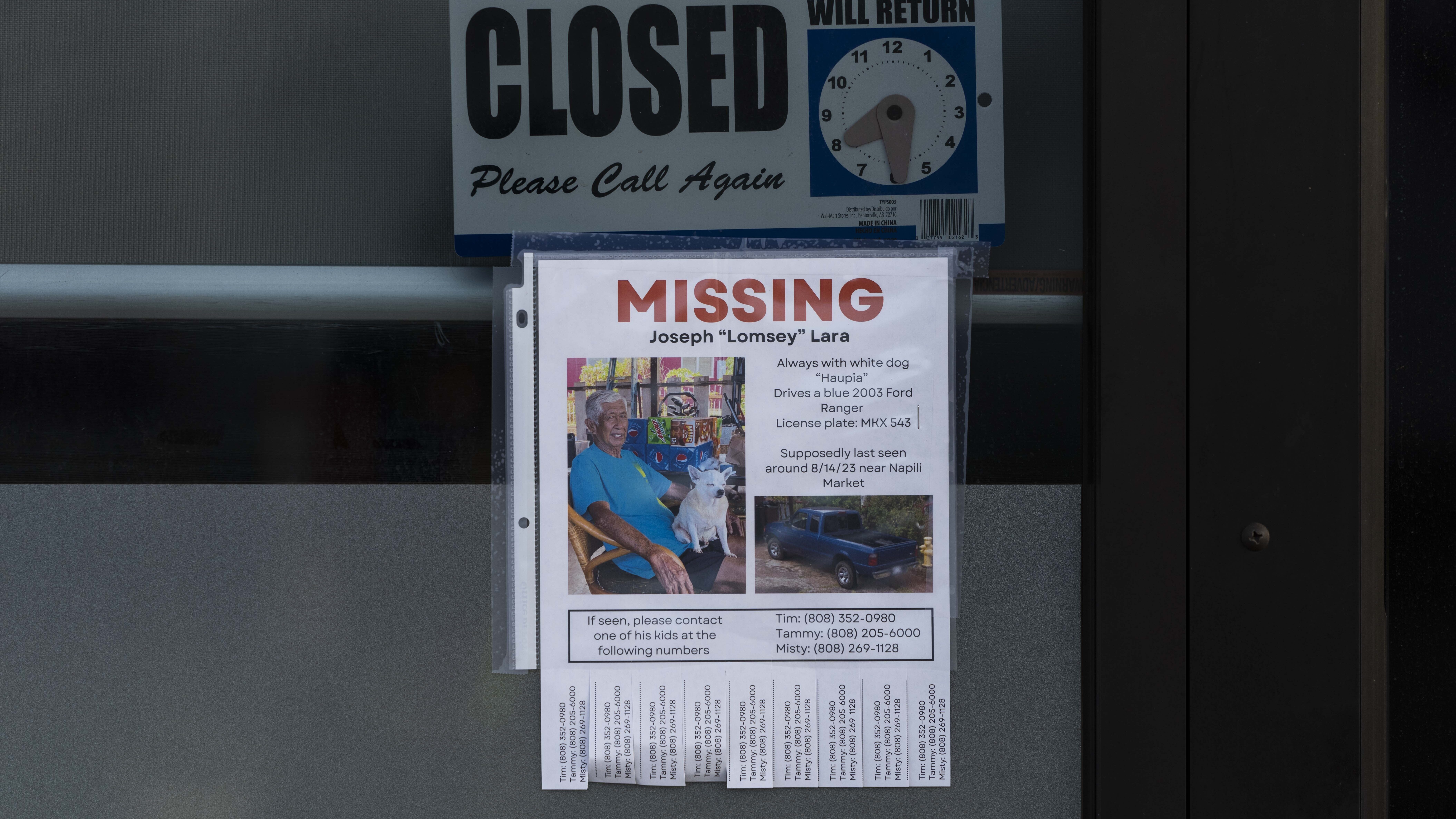 A missing person flyer for Joseph "Lomsey" Lara is posted on the door of a business in a shopping m...