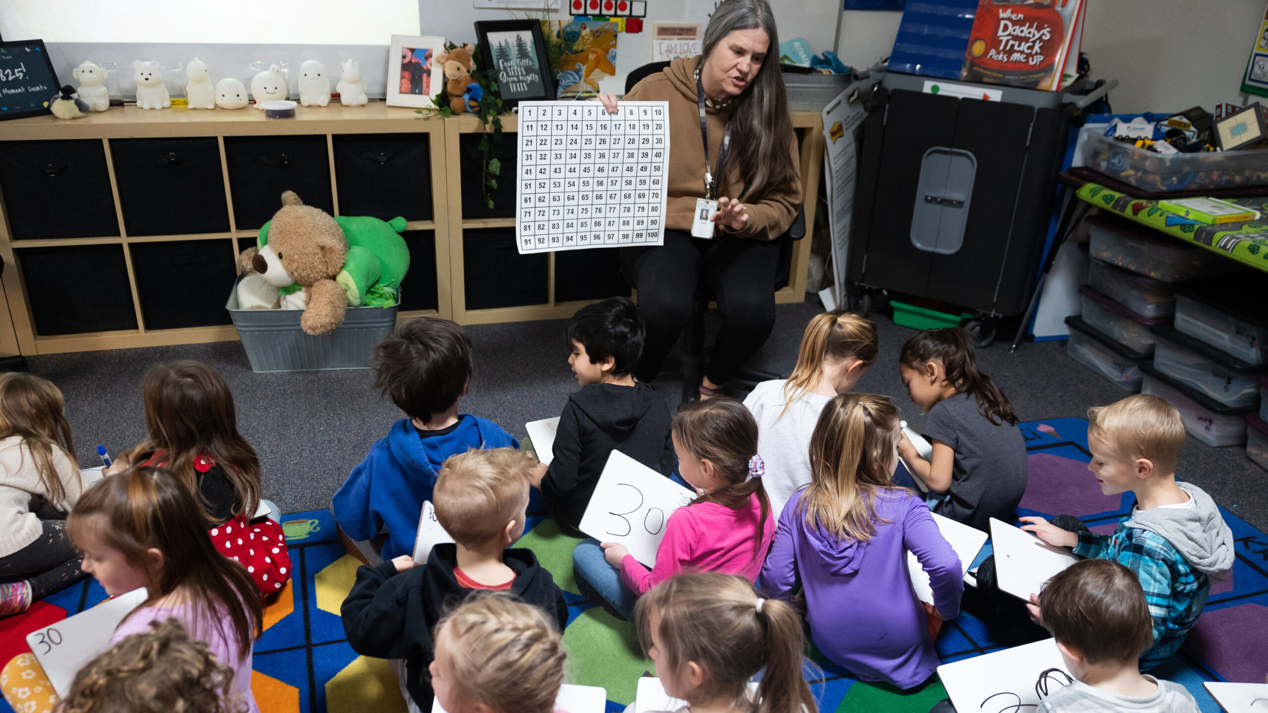 Students listen as kindergarten teacher Stephanie Cobabe gives a math lesson during a full-day kind...