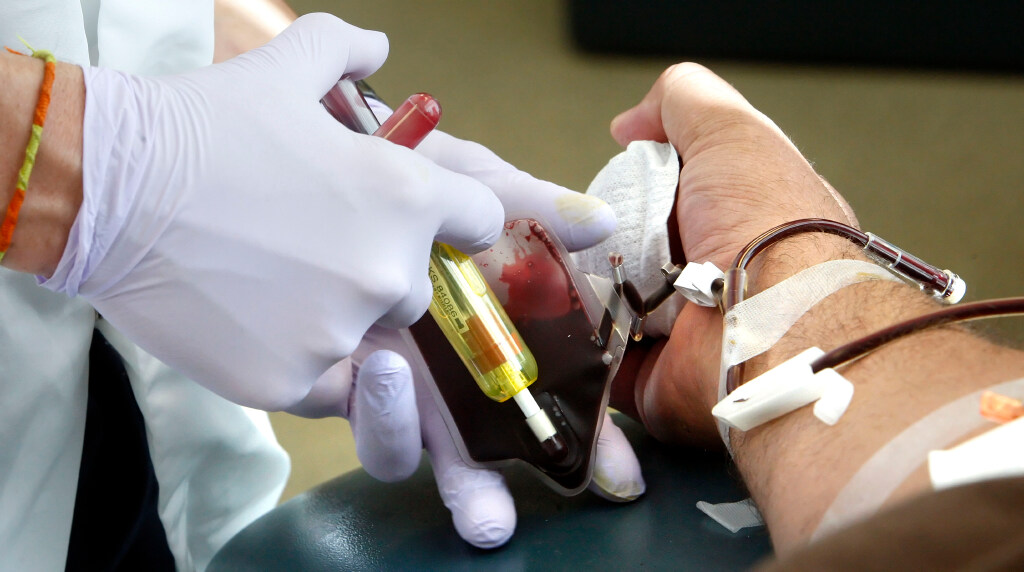 Blood flows out of a donor's arm and into a donation bag....