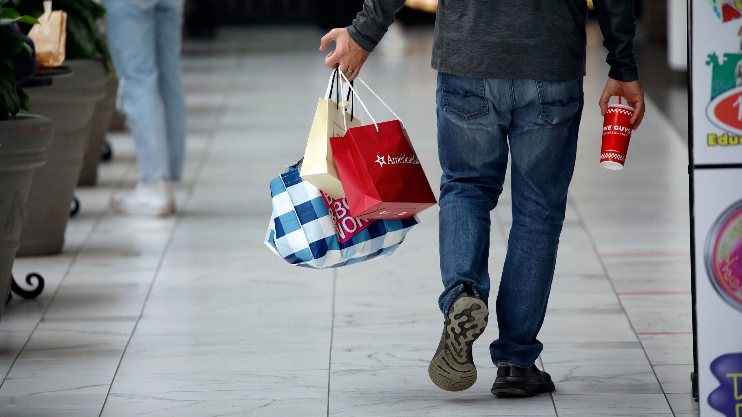 A shopper carries retail bags while walking through a shopping mall in Columbus, Ohio, U.S., on Fri...