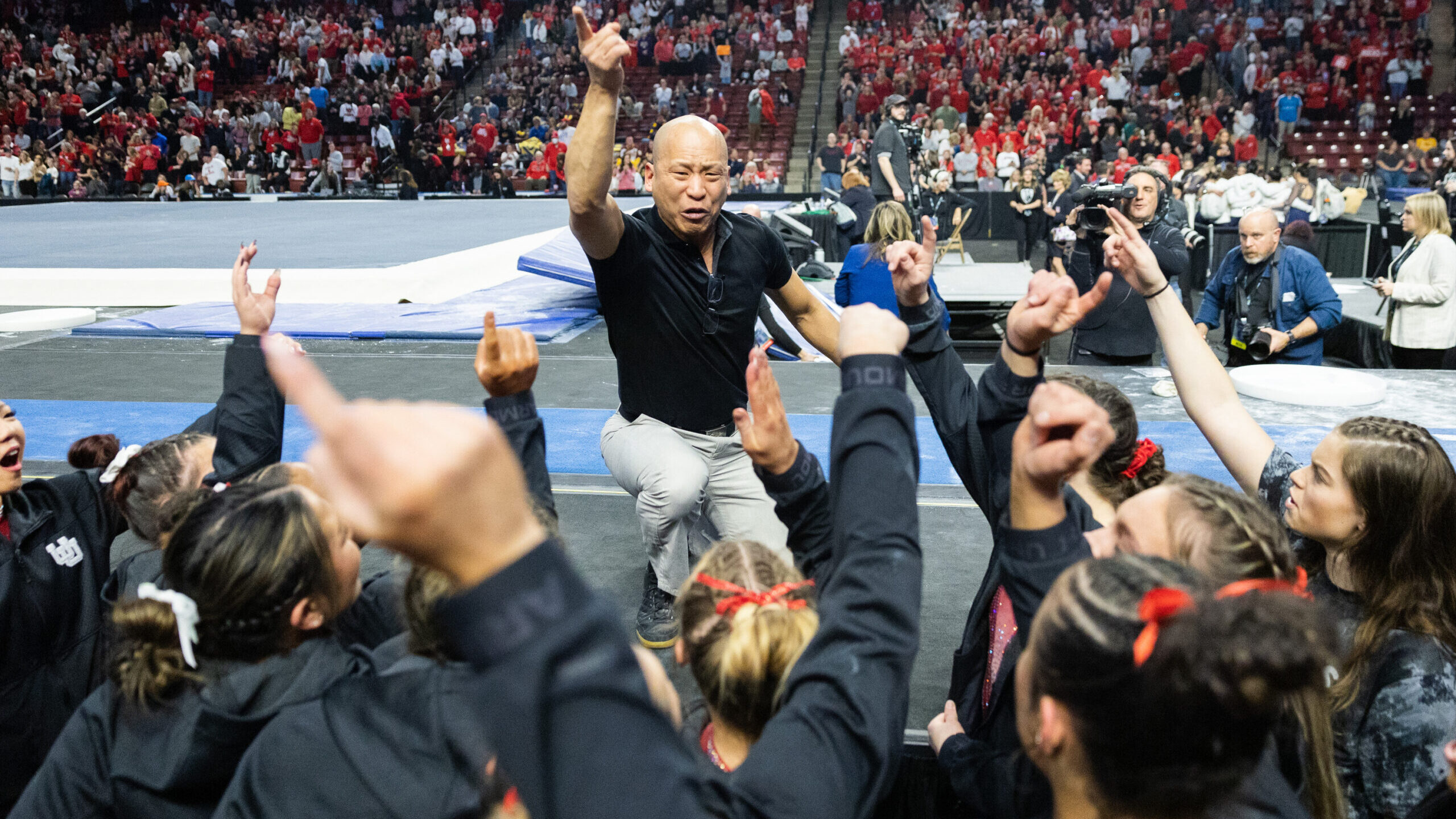 Utah’s head coach Tom Farden leads the team in a chant after winning the Pac-12 Gymnastics Champi...