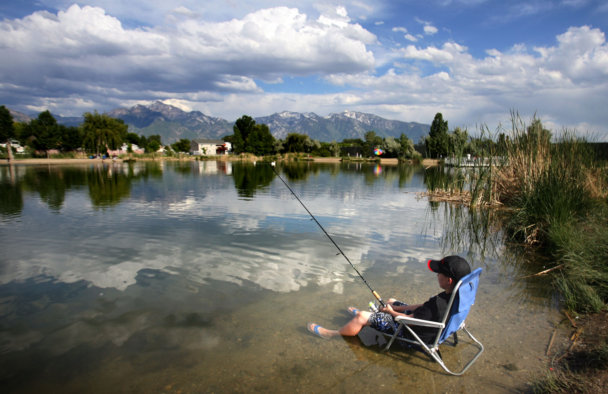Jack Walpole stays cool by sitting in his chair in the water as he and his family enjoy the day at ...