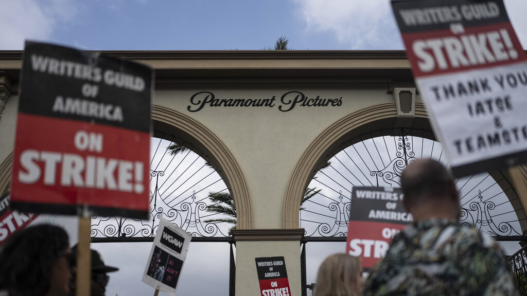 FILE - Demonstrators walk with signs during a rally outside the Paramount Pictures Studio in Los An...