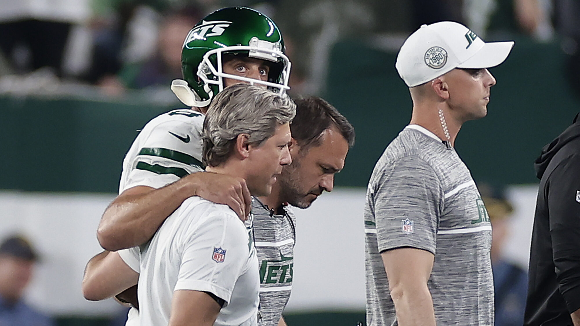 New York Jets quarterback Aaron Rodgers (8) is helped off the field during the first quarter of an ...