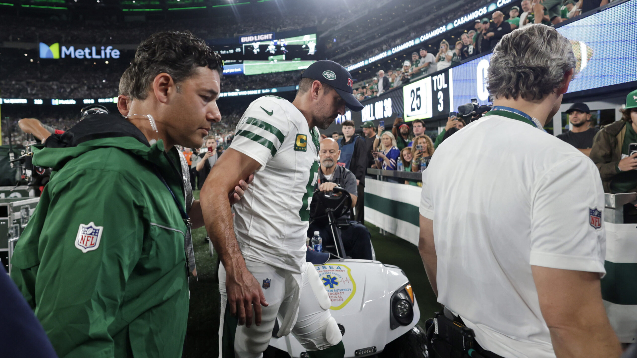 Image of New York Jets quarterback Aaron Rodgers being helped off the field after and injury during...