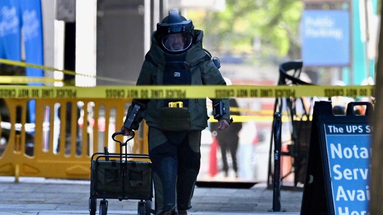 A man in a bomb suit returns from the area. (Scott G. Winterton/Deseret News)...