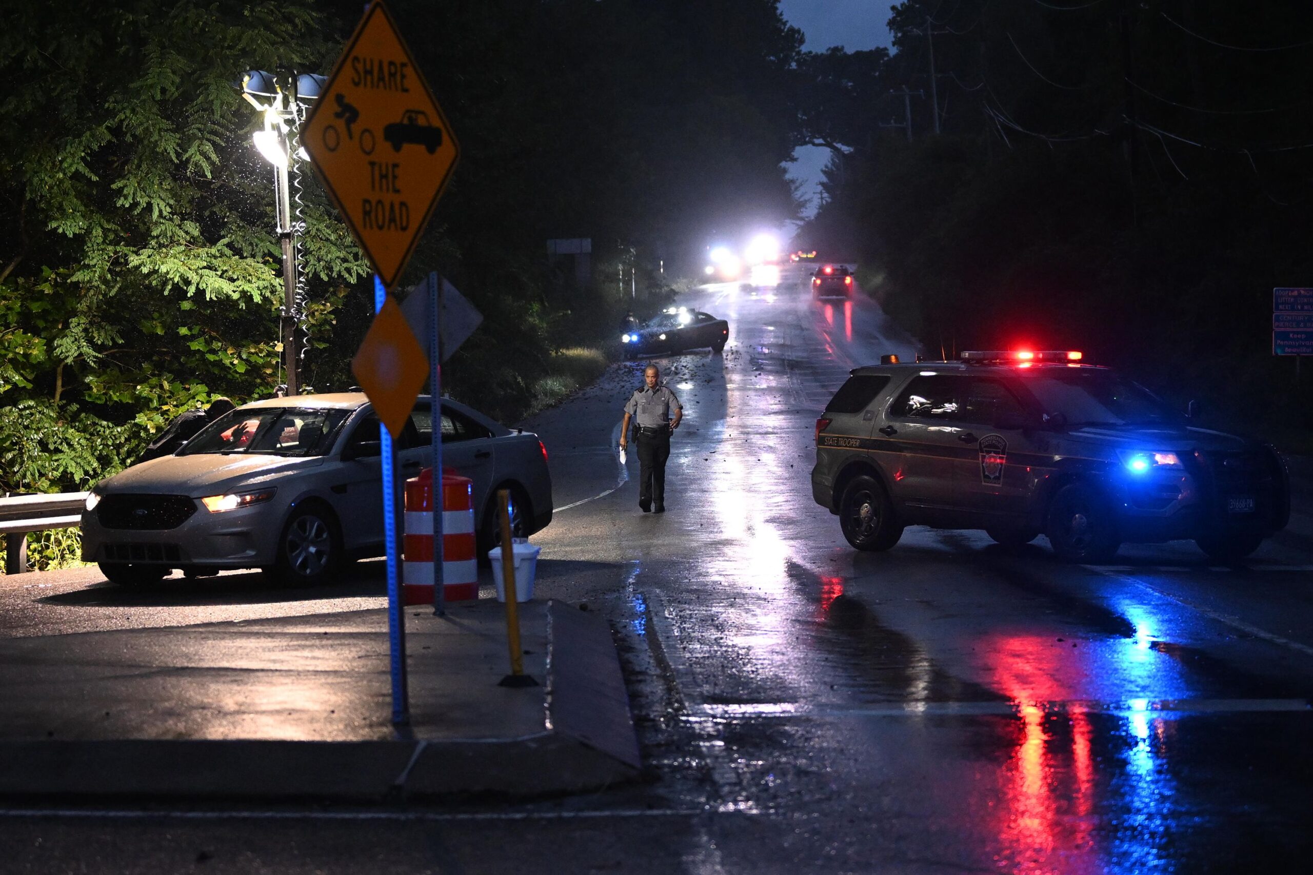 Police monitor a wooded perimeter in the rain during a manhunt for convicted murderer Danelo Cavalc...