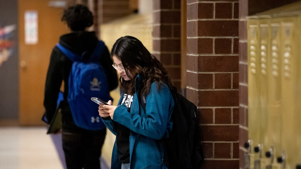 Image of a teenager using a cell phone between classes at Cyprus High School in Magna on Friday, Ja...