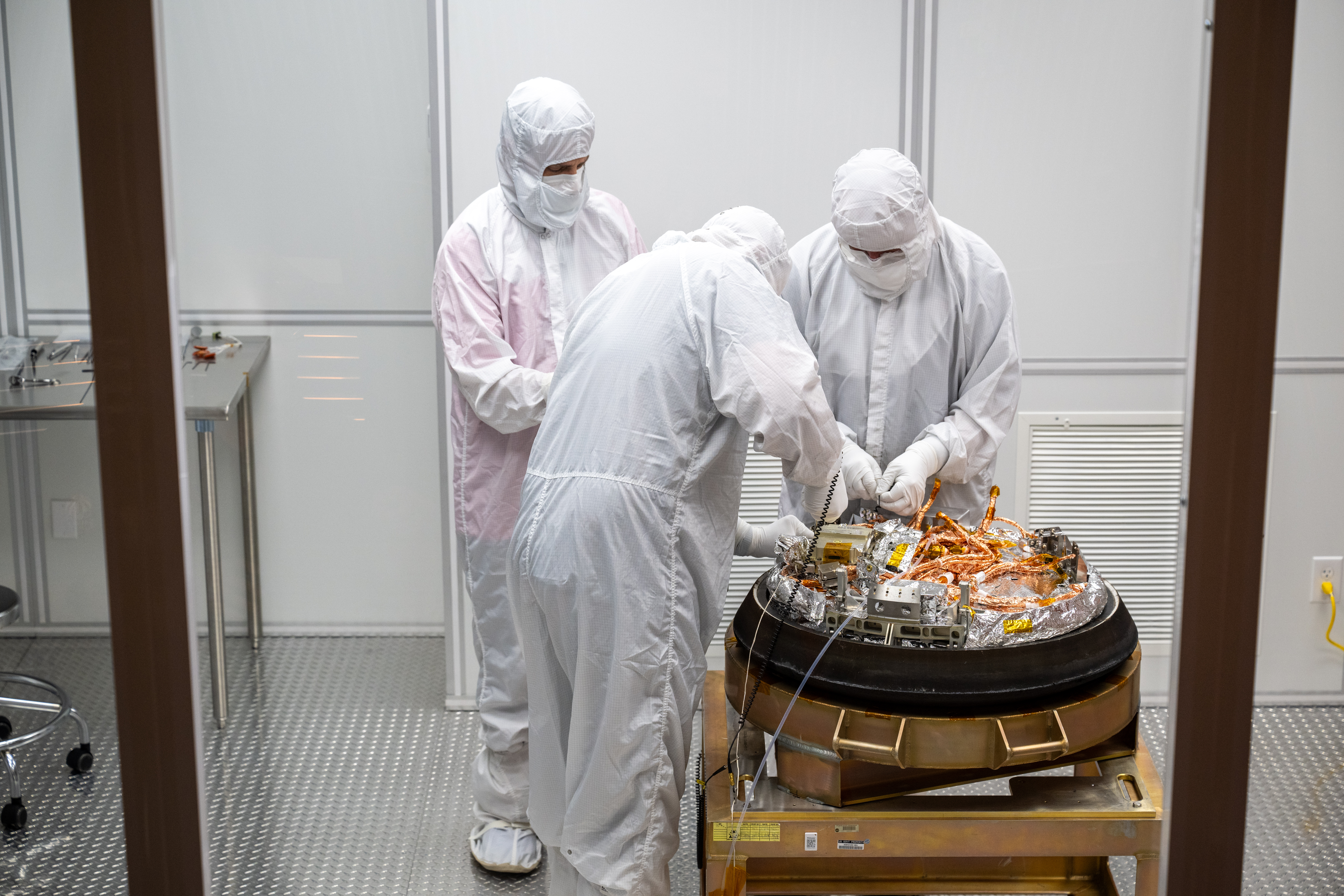 Curation teams process the sample return capsule from NASA’s OSIRIS-REx mission in a cleanroom....