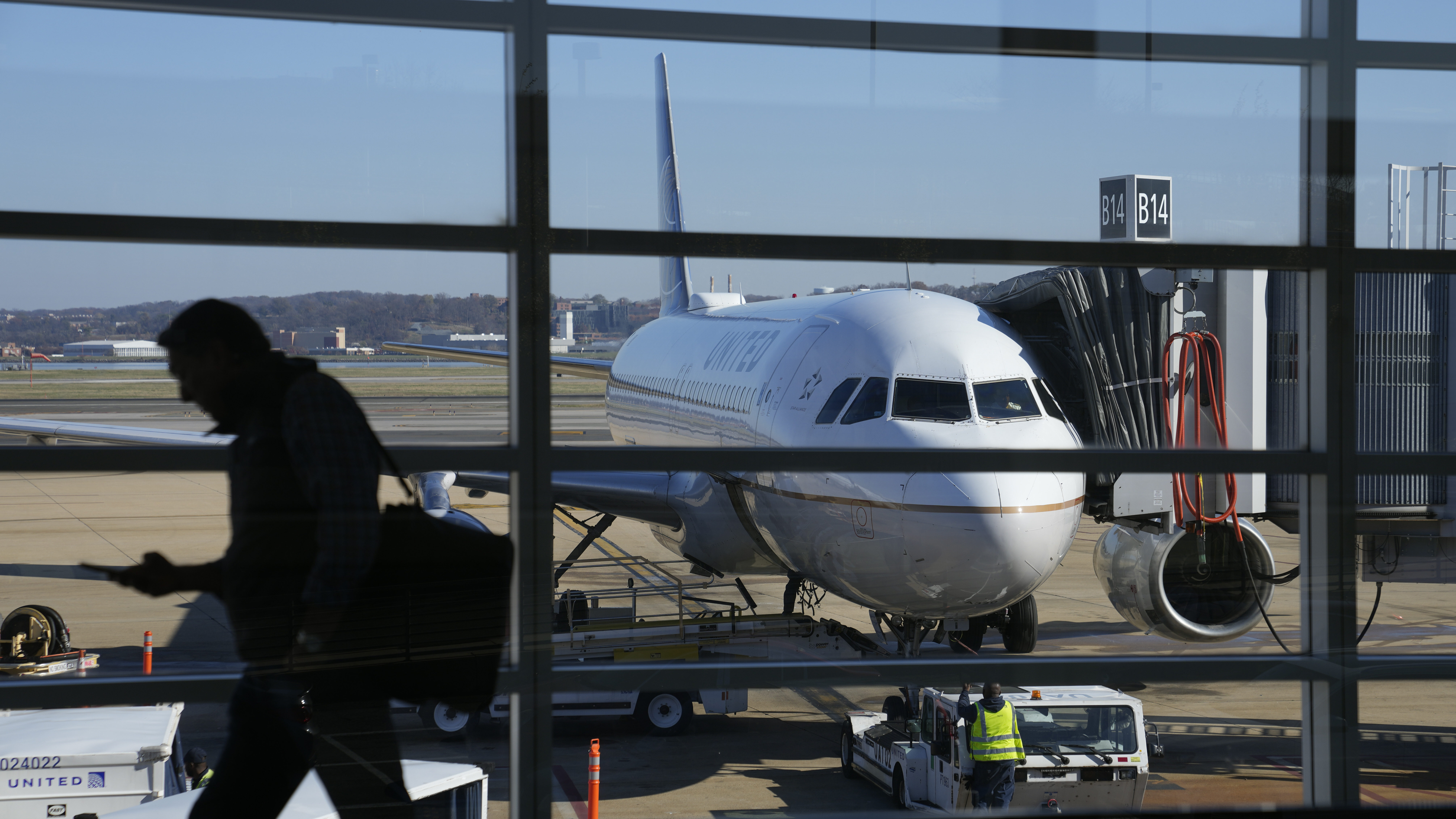 File - A United Airlines plane sits at a gate at Ronald Reagan Washington National Airport in Arlin...