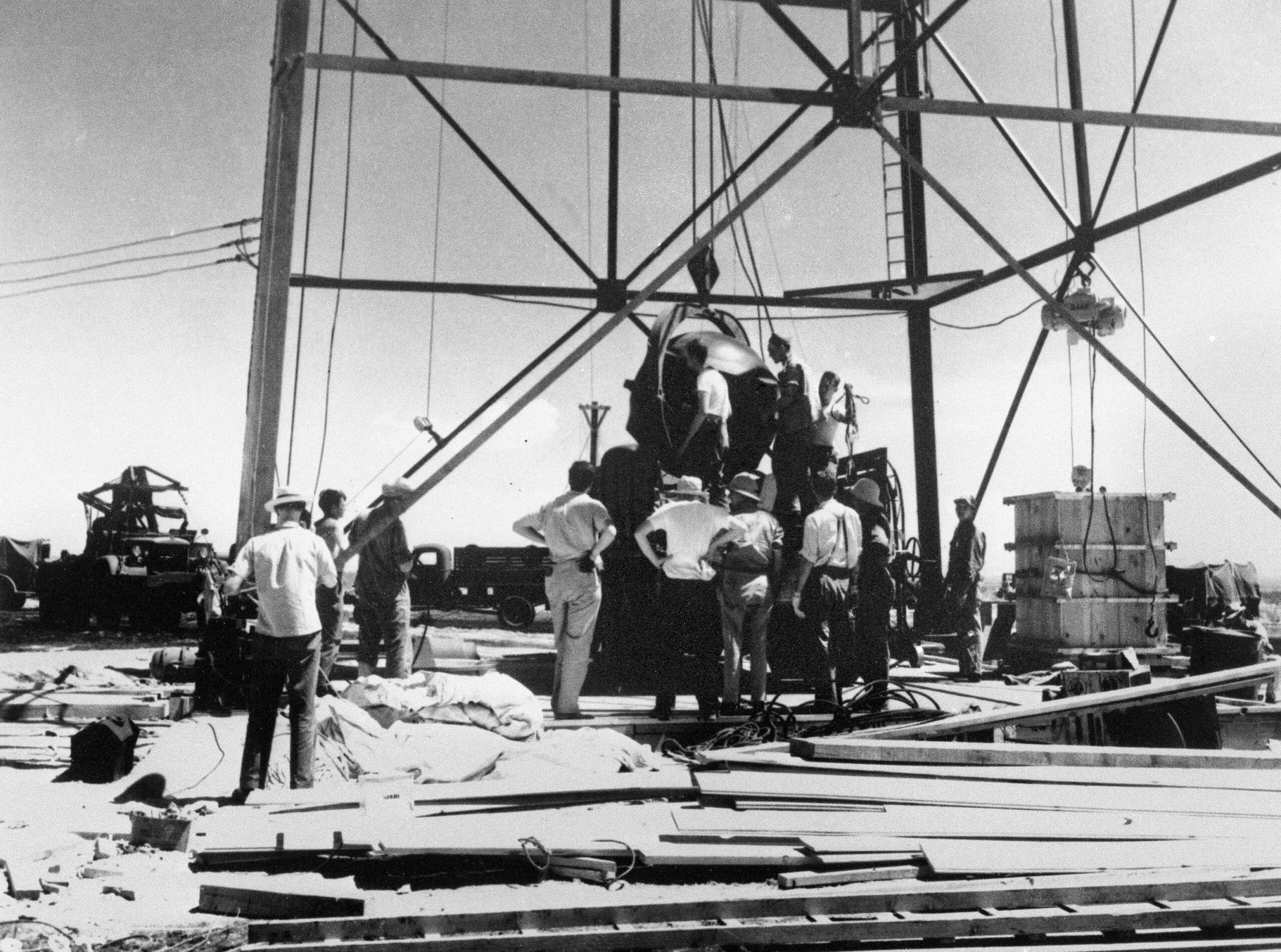 Scientists and other workers rig the world's first atomic bomb to raise it up onto a 100-foot tower at the Trinity Test Site near Alamogordo, N.M. 
