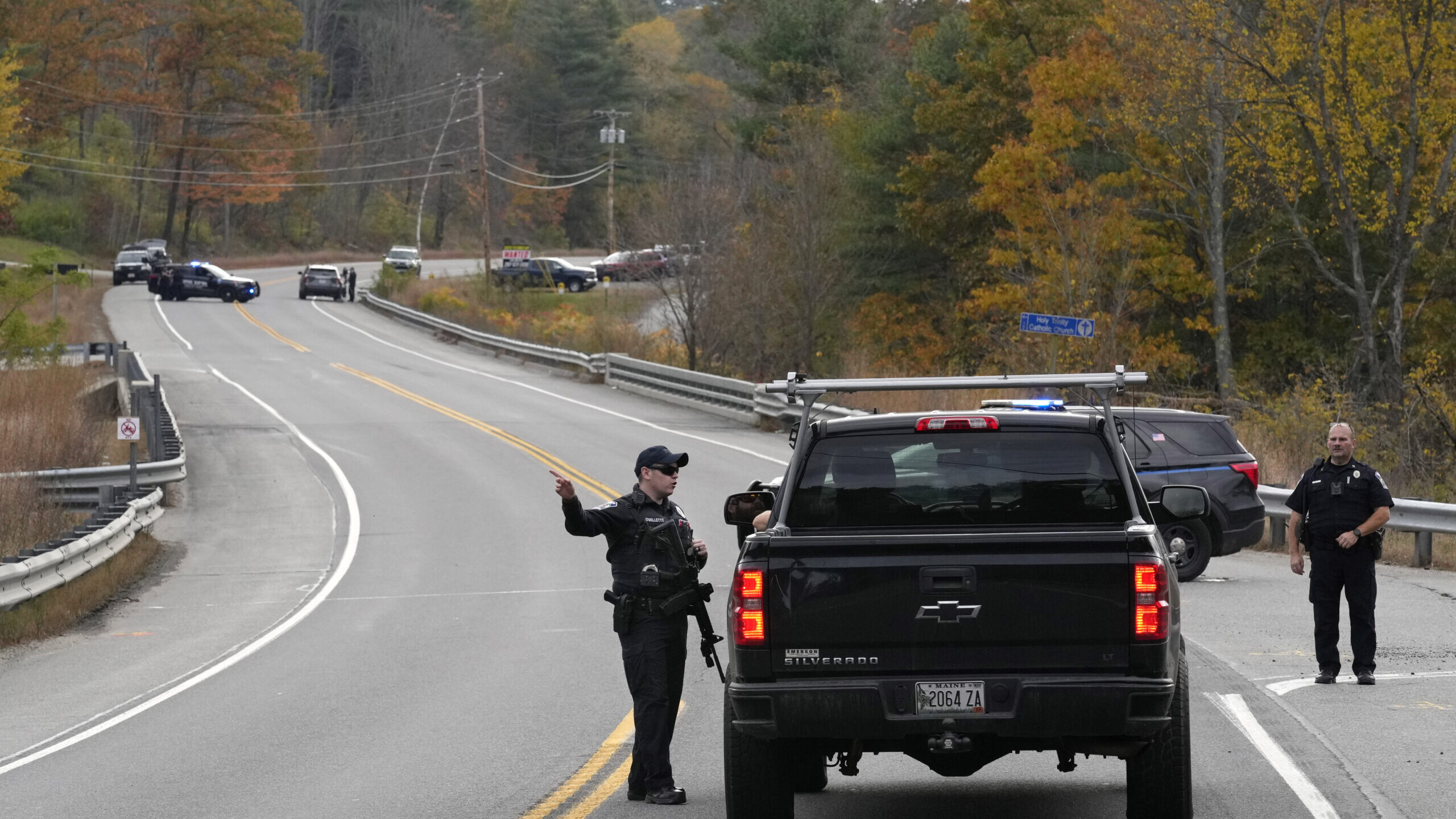 Police officers speak with a motorist at a roadblock, Thursday, Oct. 26, 2023, in Lisbon, Maine, du...