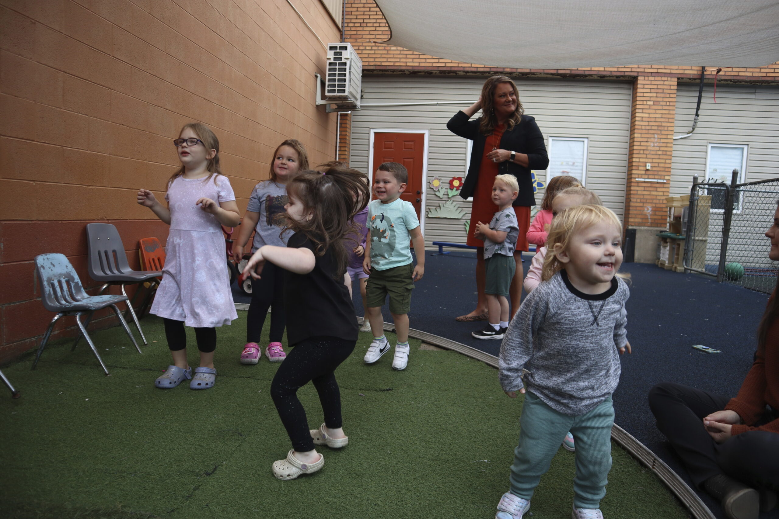 Toddlers dance during play time at Living Water Child Care and Learning Center as center director J...