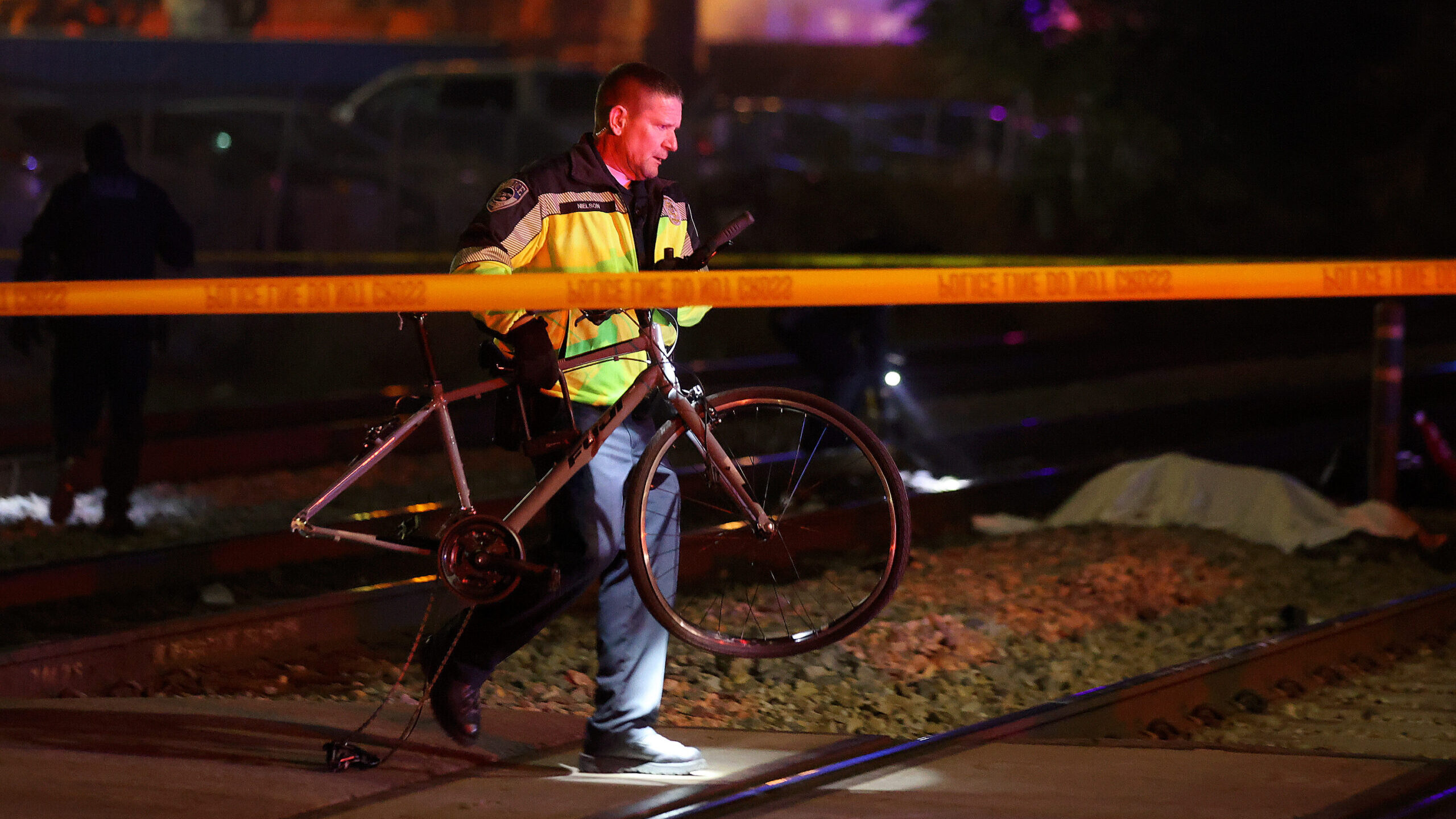 Emergency responders work at the scene of an accident after a cyclist was fatally hit by a FrontRun...