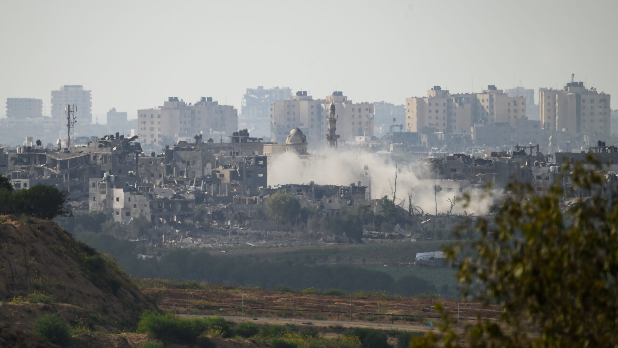 A plume of smoke rises following an artillery strike within Gaza on October 19, 2023, as seen from ...