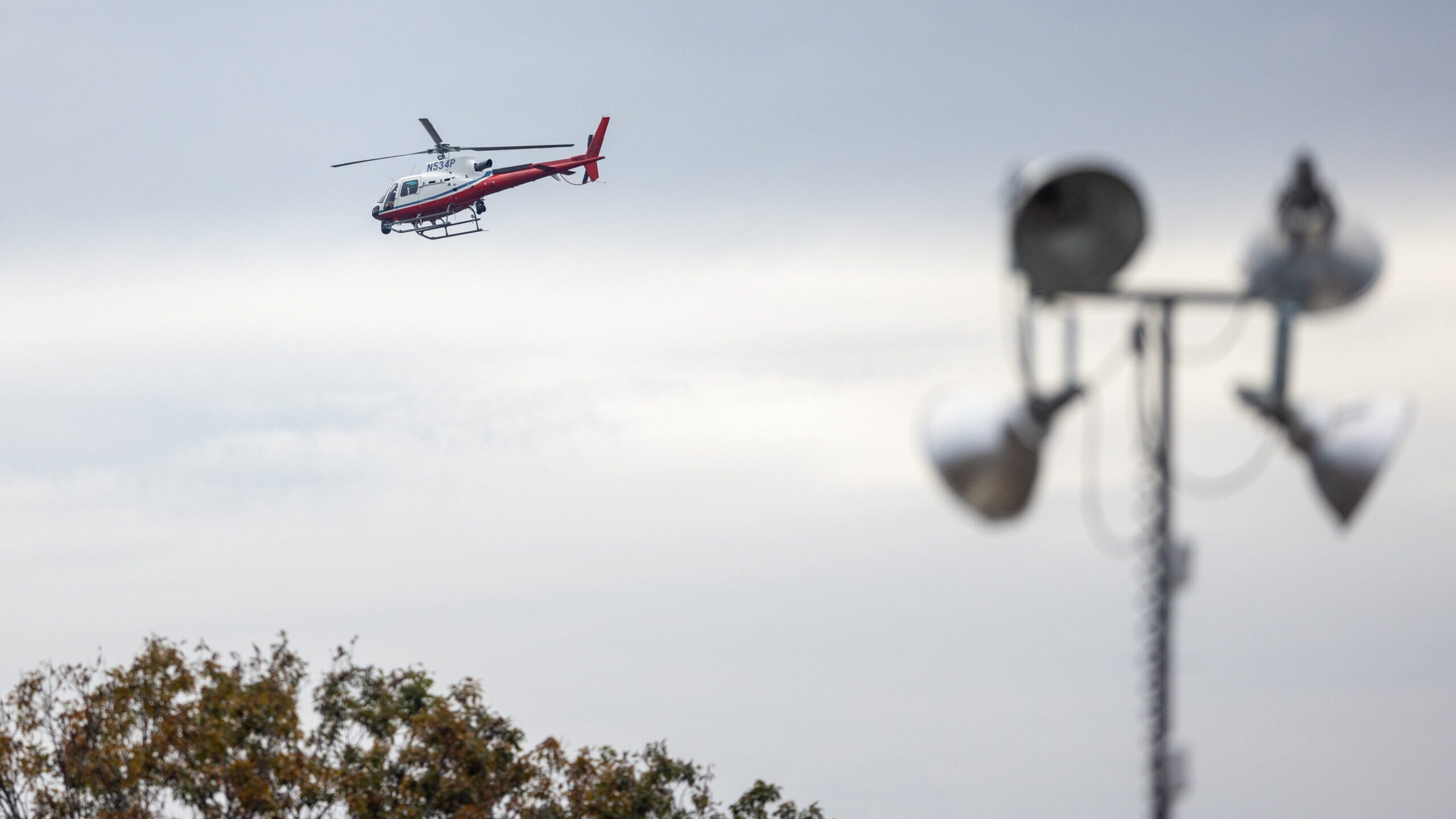 A helicopter flies low along the Androscogin River during the manhunt for the suspect in a mass sho...