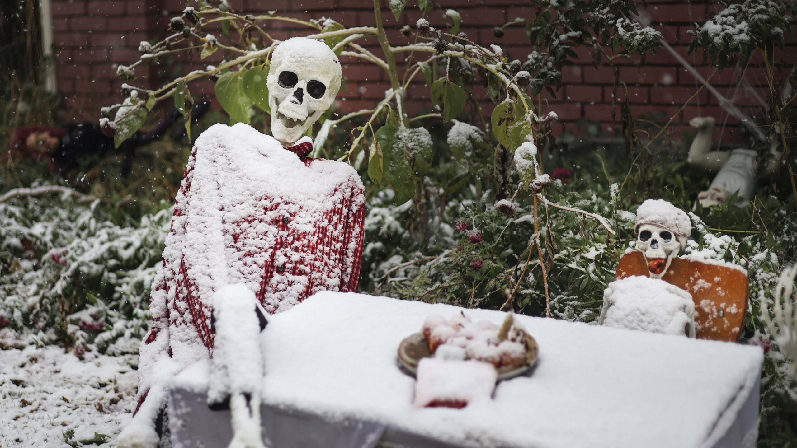 Image of Halloween decorations covered in snow at a home in Salt Lake City. There are dozens of pla...