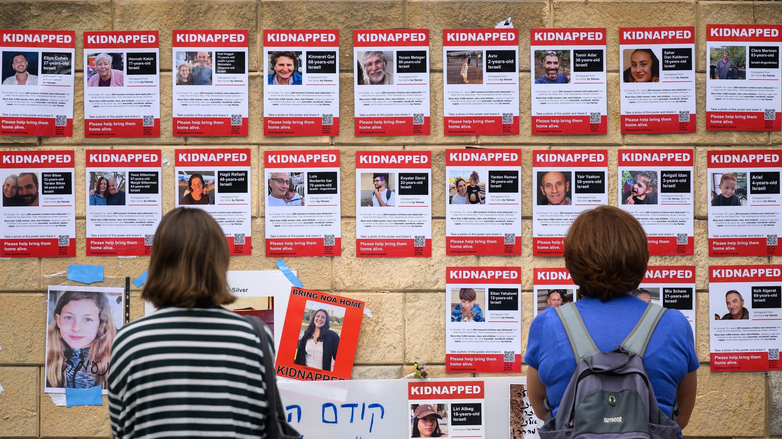 Photographs of some of the people taken hostage by Hamas are seen in posters on October 18, in Tel ...