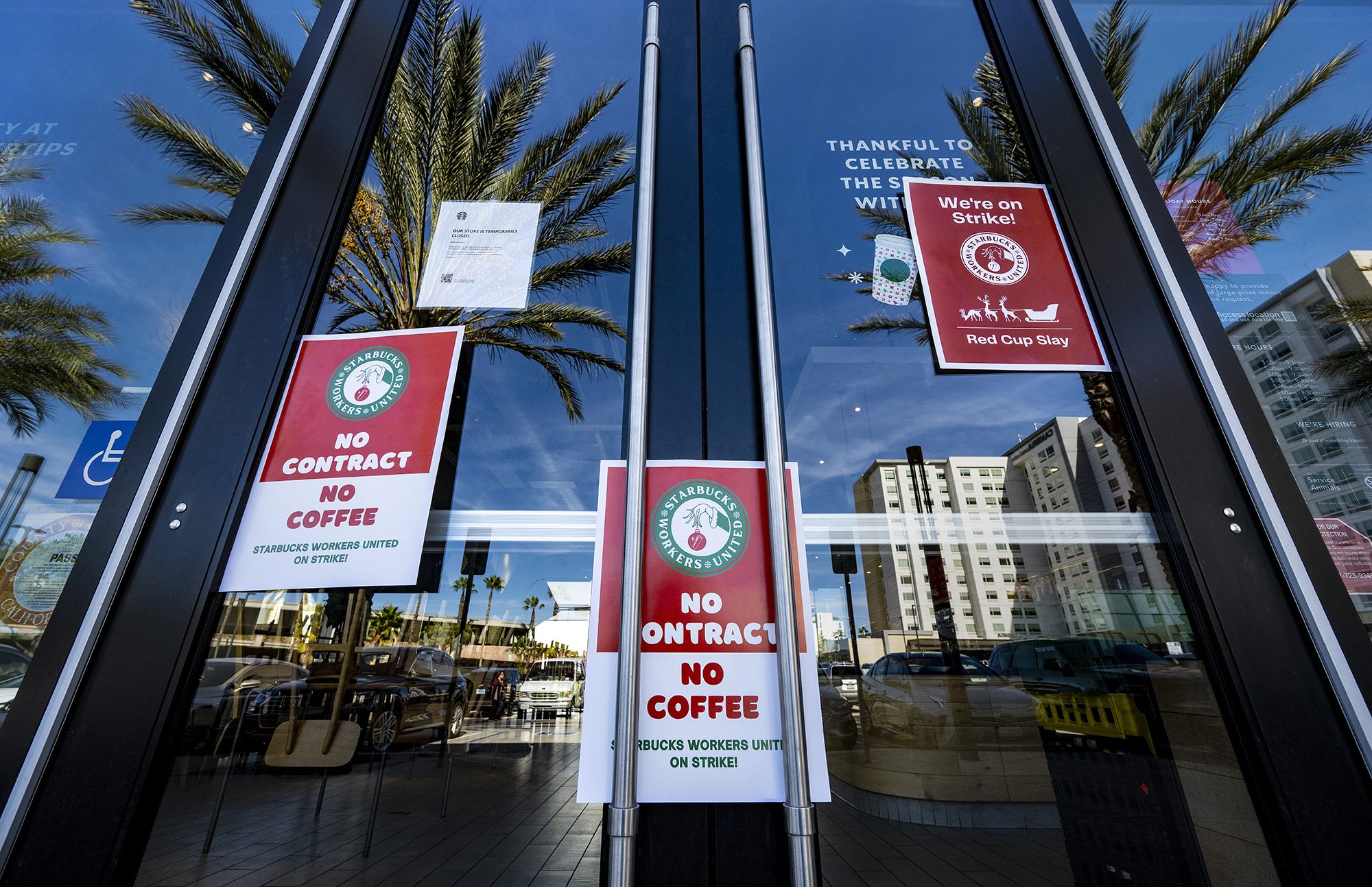 Signs are posted on the door of a closed unionized Starbucks Coffee in Anaheim, at its strike a yea...