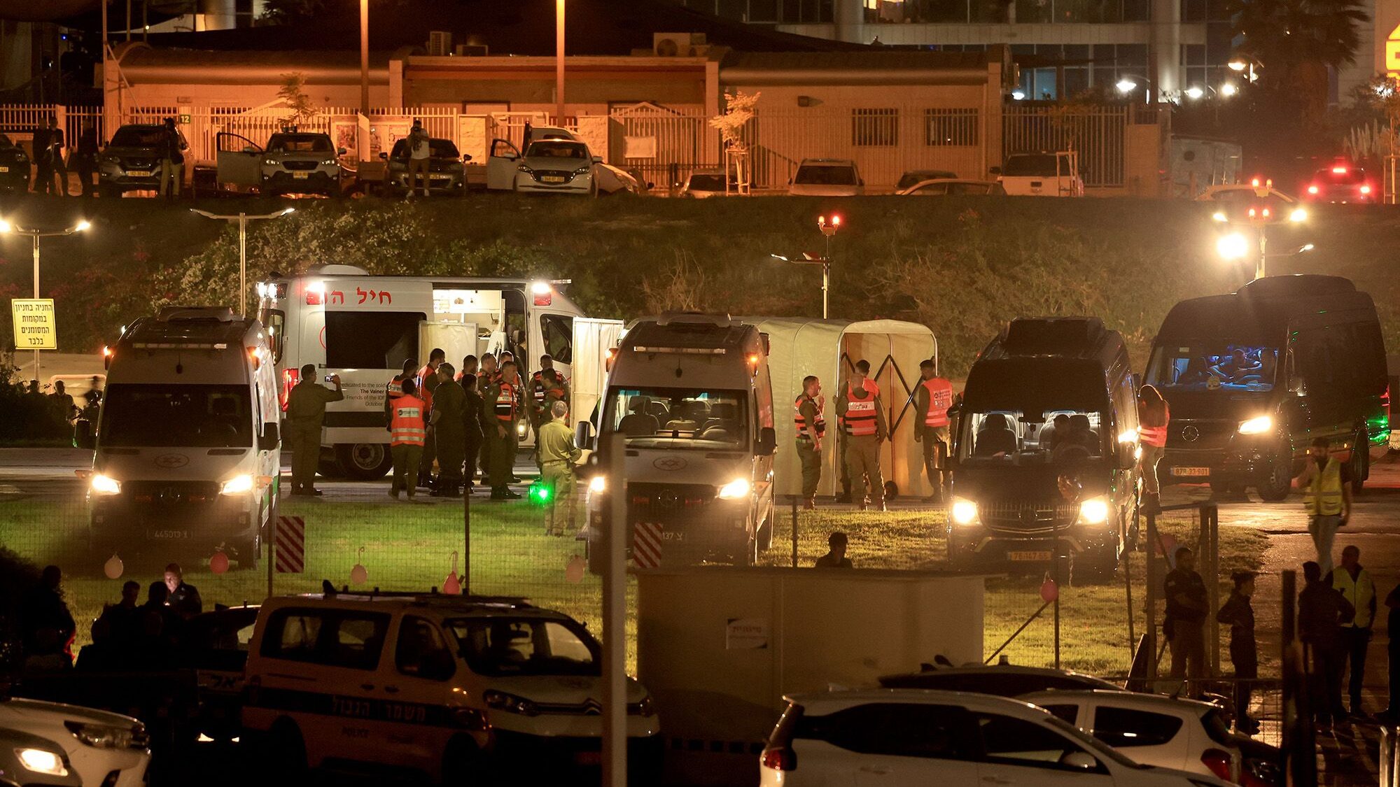 Israeli security forces stand next to ambulances waiting outside the helipad of Tel Aviv's Schneide...