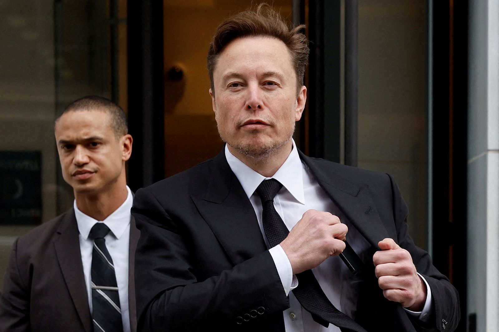 Tesla CEO Elon Musk and his security detail depart the company's local office in Washington, U.S. J...