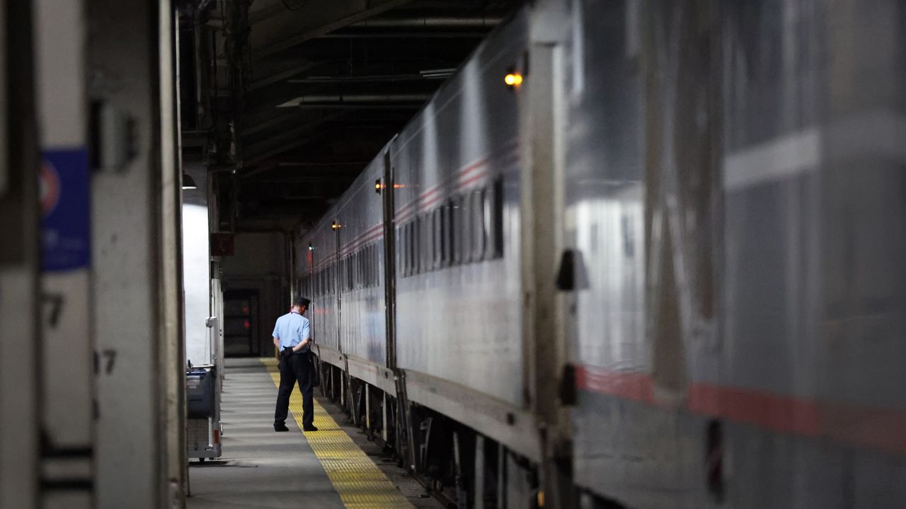 An Amtrak conductor flanks a train to Milwaukee at Union Station in Chicago, Illinois....