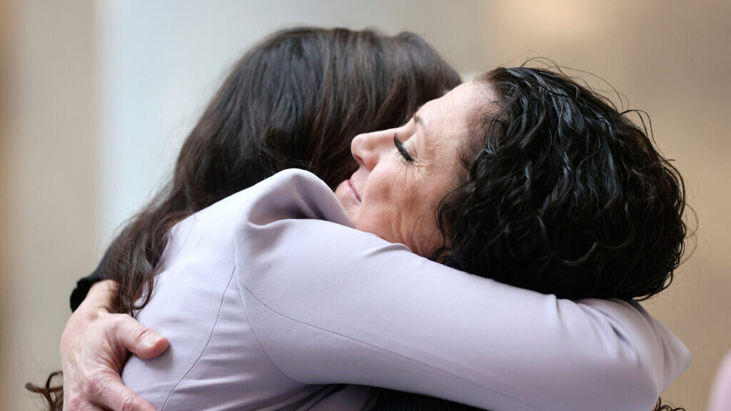 Shonie Christensen, domestic violence advocate and survivor, hugs Lindsey Boyer,...