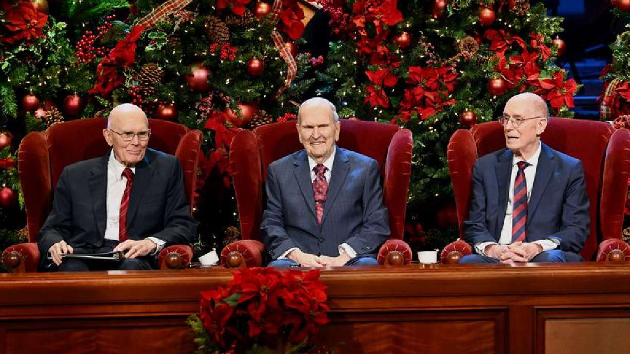 President Russell M. Nelson of The Church of Jesus Christ of Latter-day Saints sits between his cou...