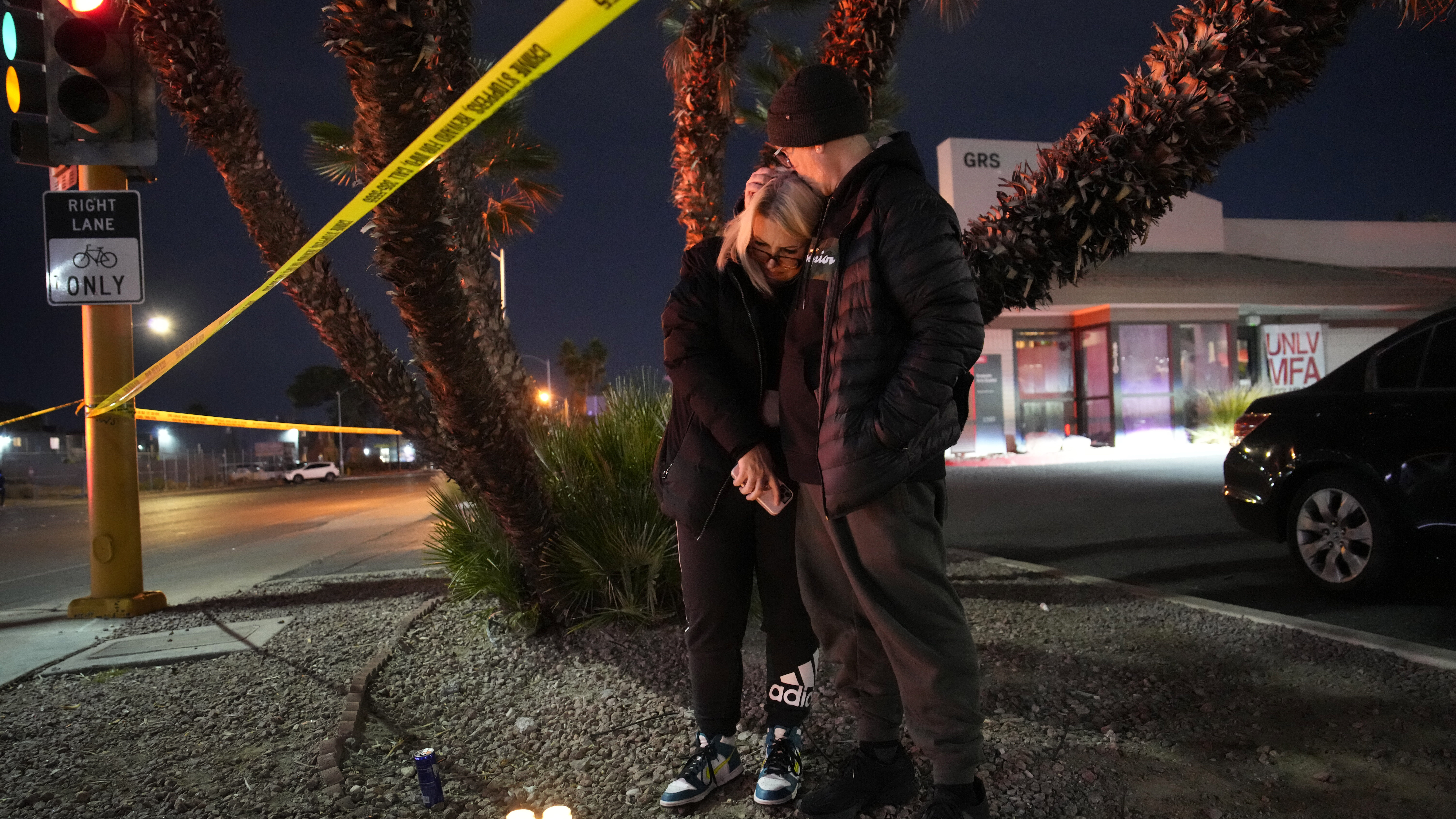 Sean Hathcock, right, kisses Michelle Ashley after the two left candles for victims of a shooting a...