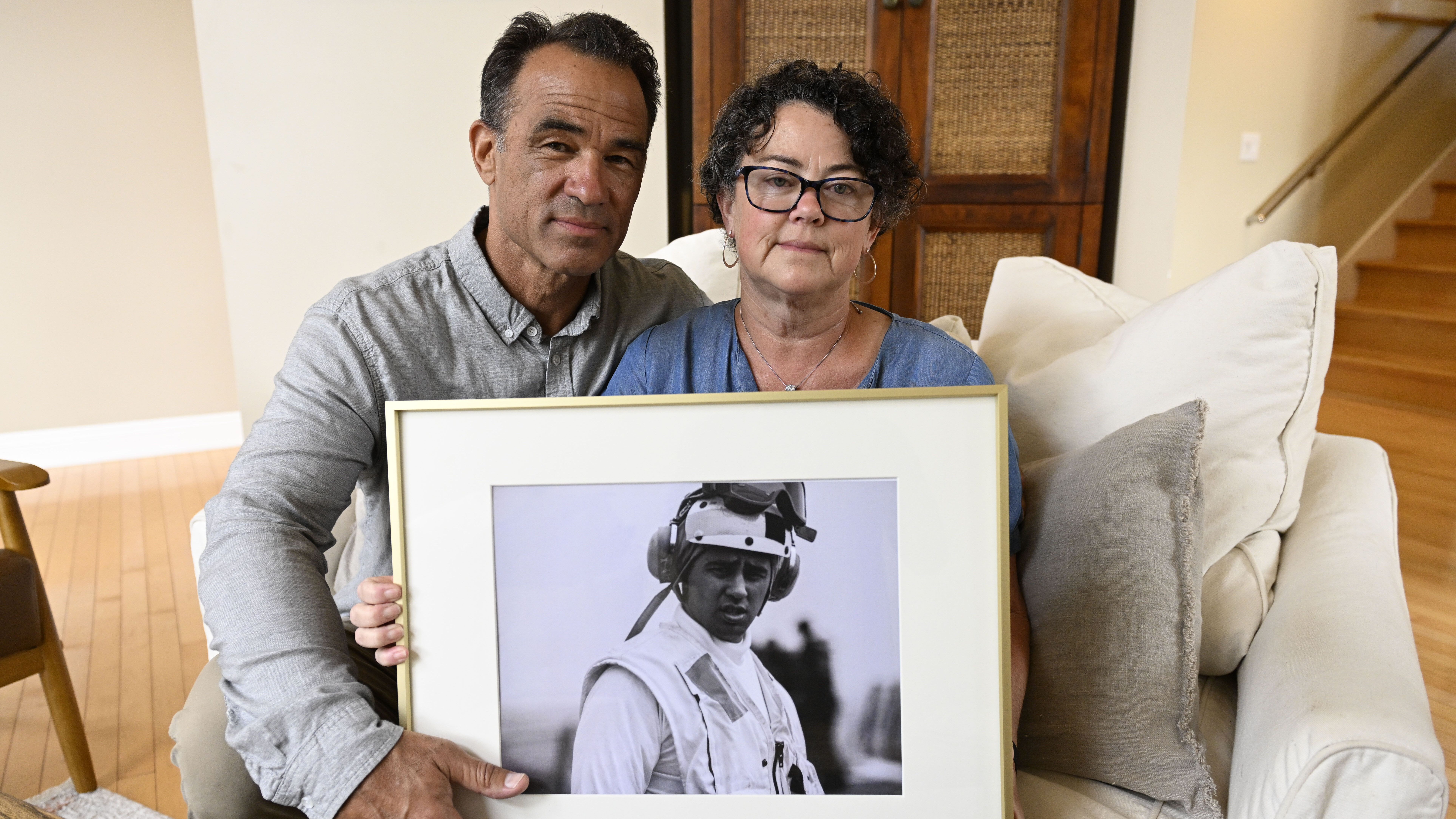 FILE - Derek and Suzi Alkonis pose with a photo of their son Lt. Ridge Alkonis on Wednesday, June 1...