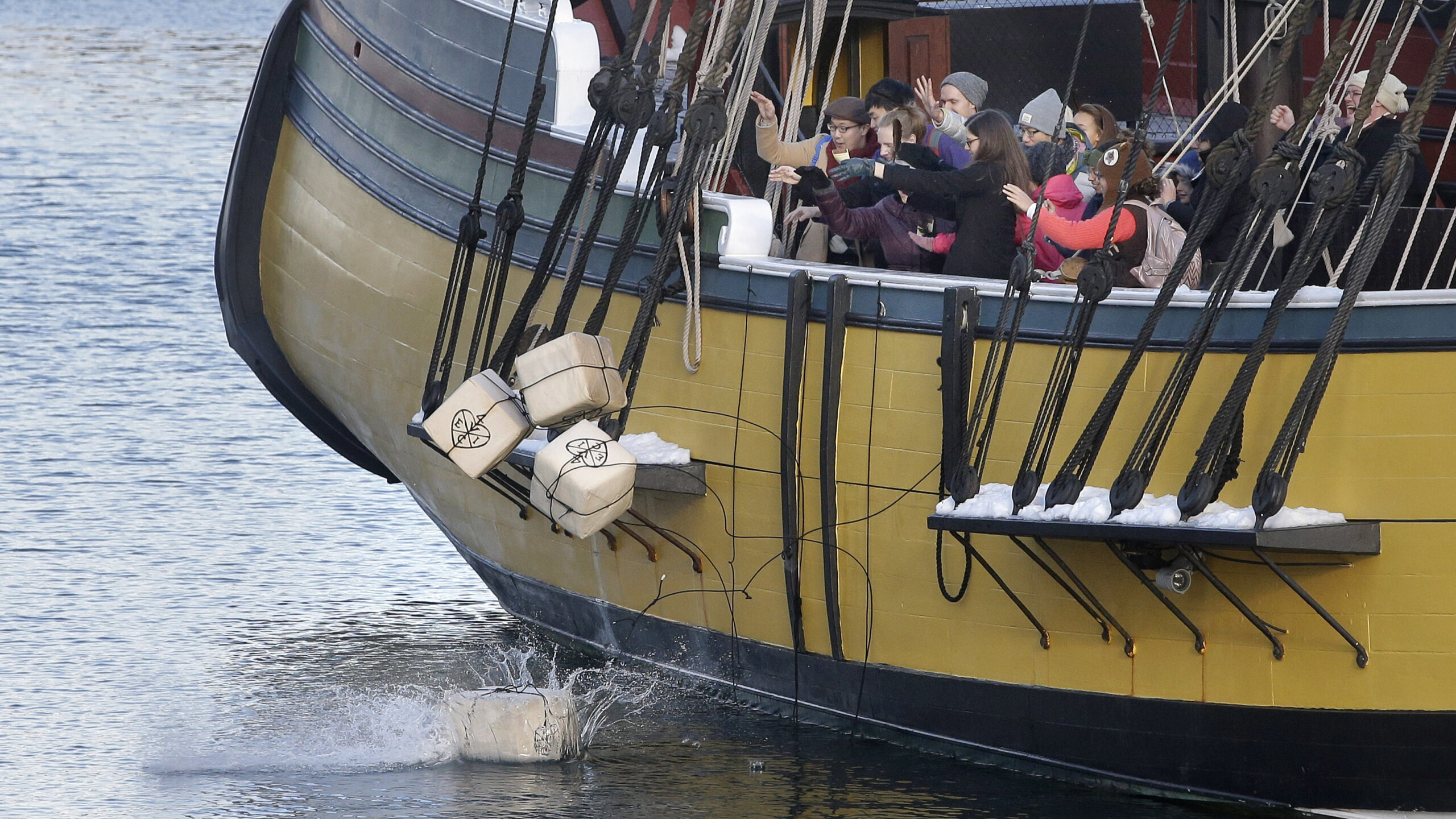 visitors to the Boston Tea Party Museum throw replicas of historic tea containers into Boston Harbo...