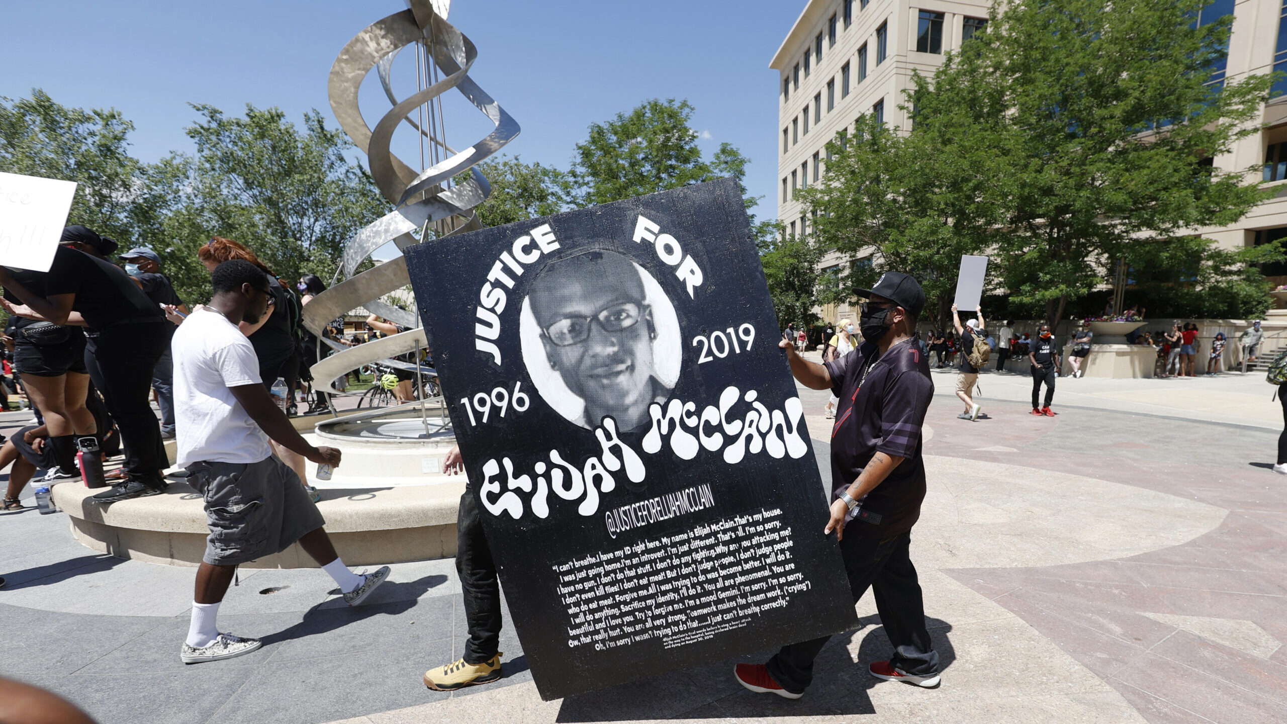 FILE - Demonstrators carry a giant placard during a rally and march over the death of 23-year-old E...