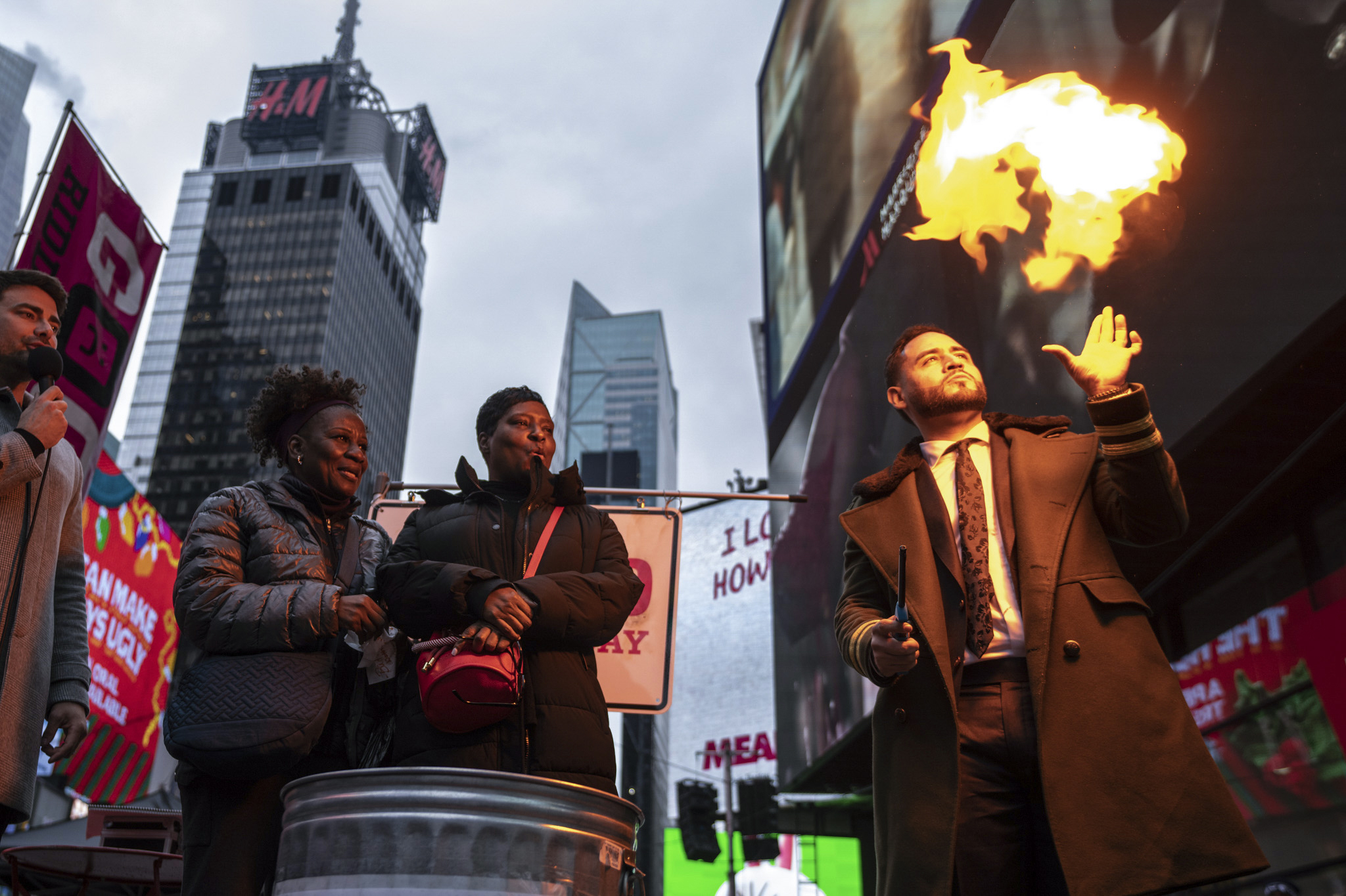 Magician Devonte Rosero, right, burns notes written by people in Times Square in New York, Thursday...
