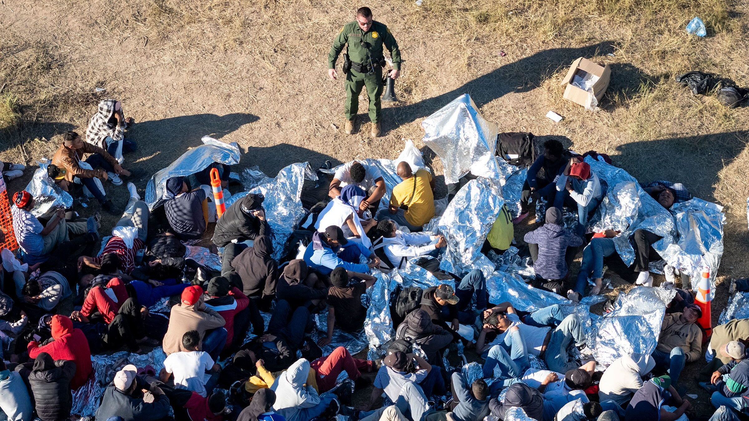 A US Border Patrol agent speaks with immigrants waiting to be processed after crossing from Mexico ...