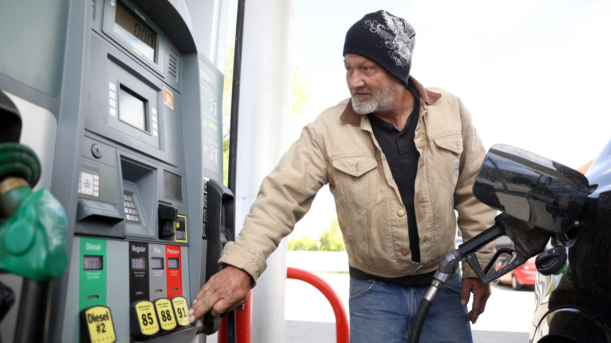 man pumps gas, gas prices will stay low as the new year starts...