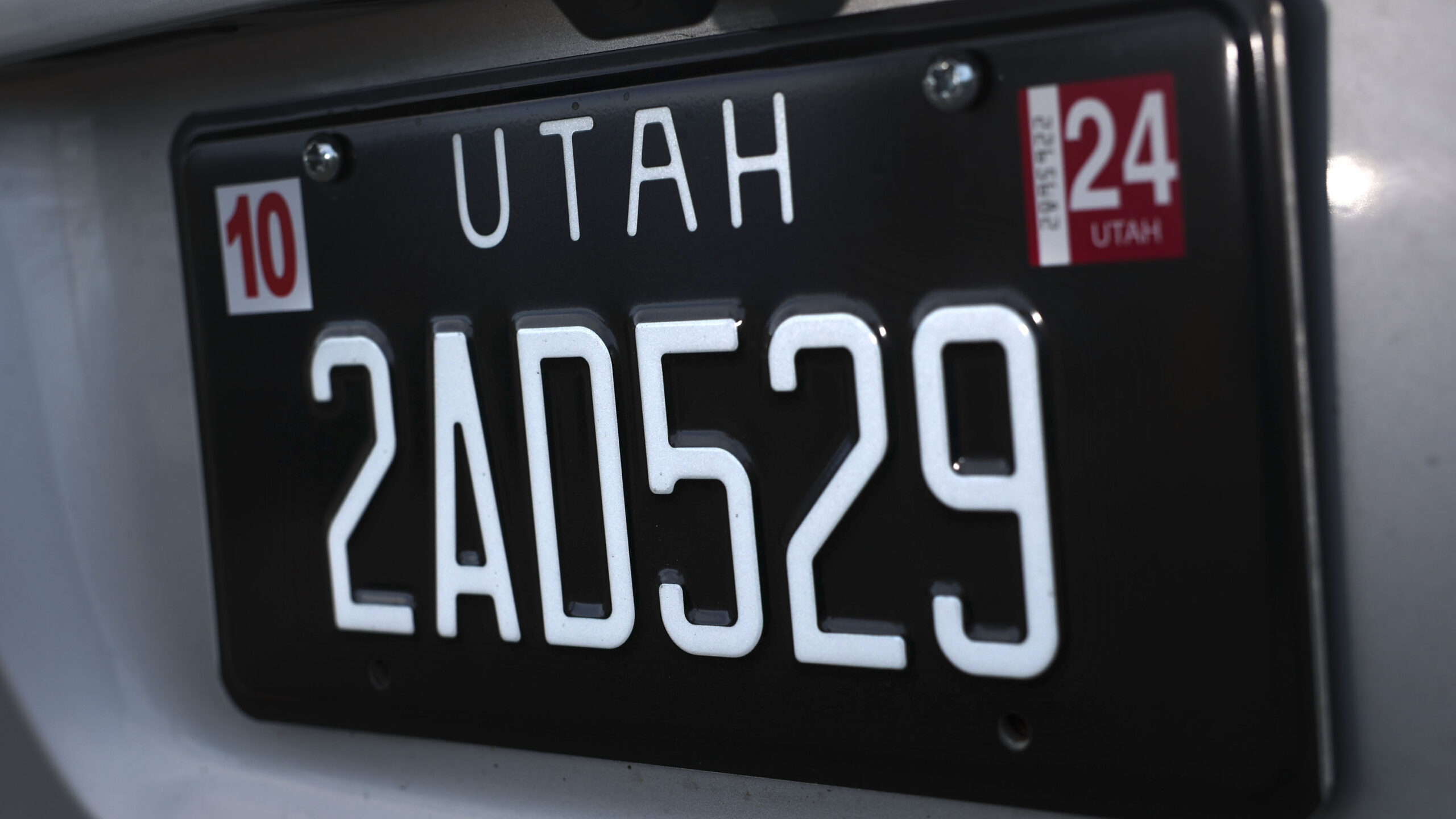 Black Utah license plate with registration stickers...