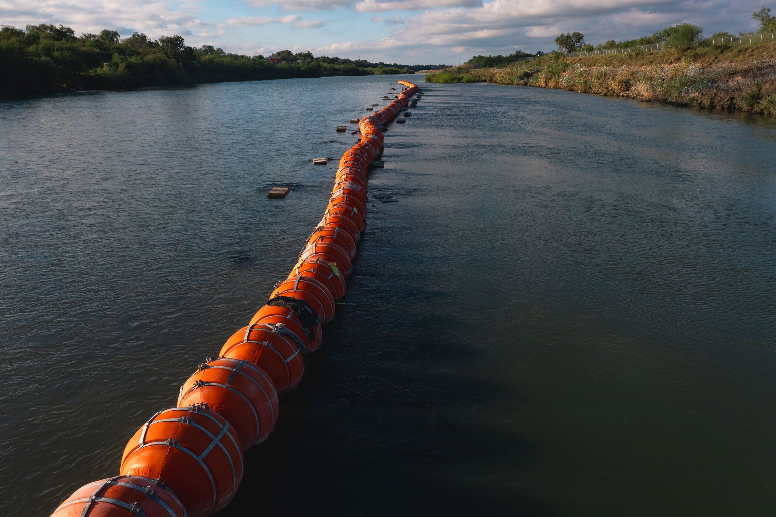 Buoys meant to deter migrant crossings are anchored in the Rio Grande River in Eagle Pass, Texas, o...