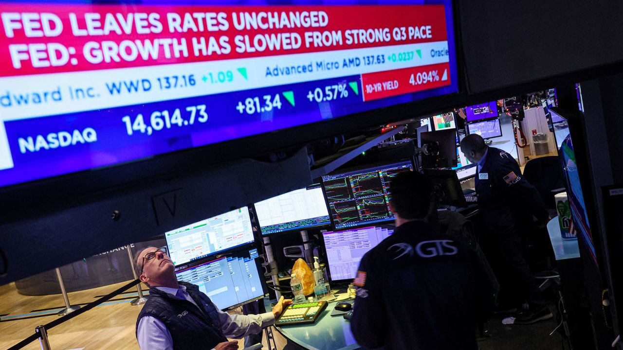 Traders react as a screen displays the Fed rate announcement on the floor of the New York Stock Exc...