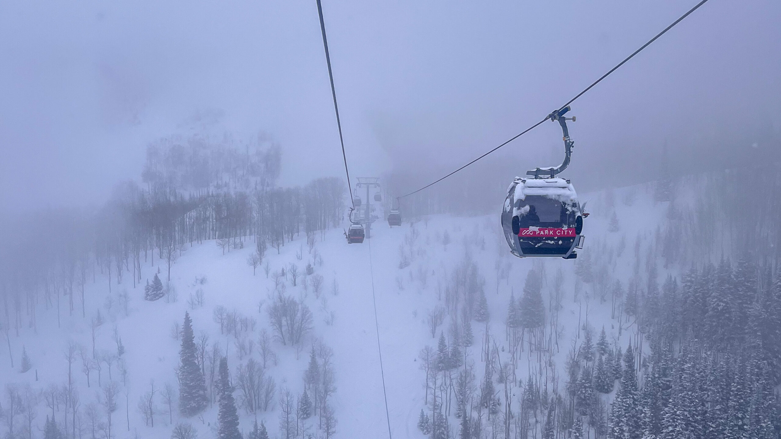Quicksilver gondola cabins travel along a cable on a snowy day at Park City Mountain Resort....