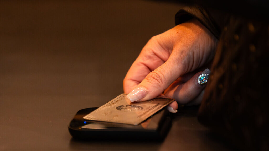 A customer taps her card to pay on Black Friday at Tecovas at City Creek Center in Salt Lake City o...