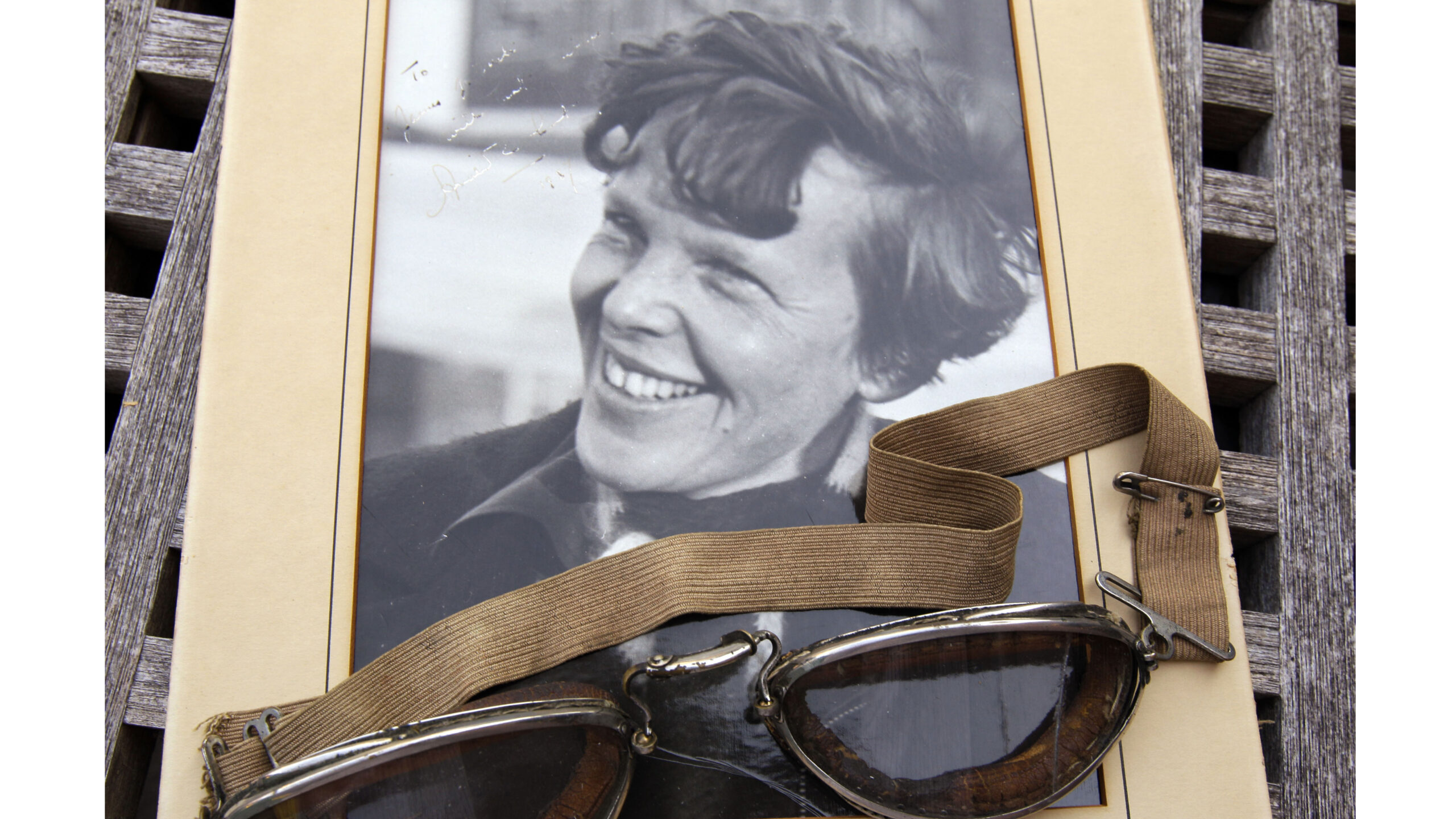 FILE - An original, unpublished personal photo of Amelia Earhart dated 1937, along with goggles she...