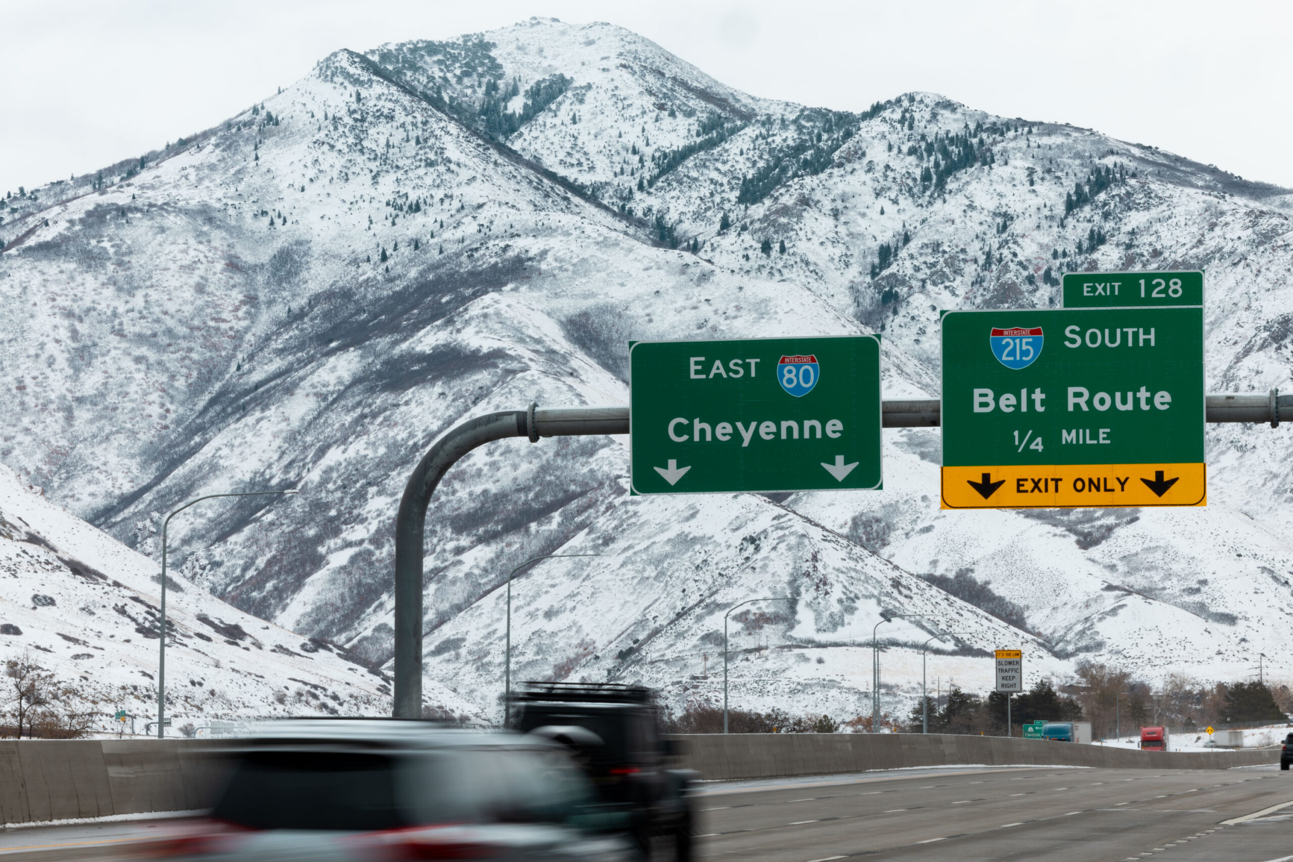 Cars drive on I-80 with a snowy mountain backdrop after snowstorms hit the Wasatch Front throughout...