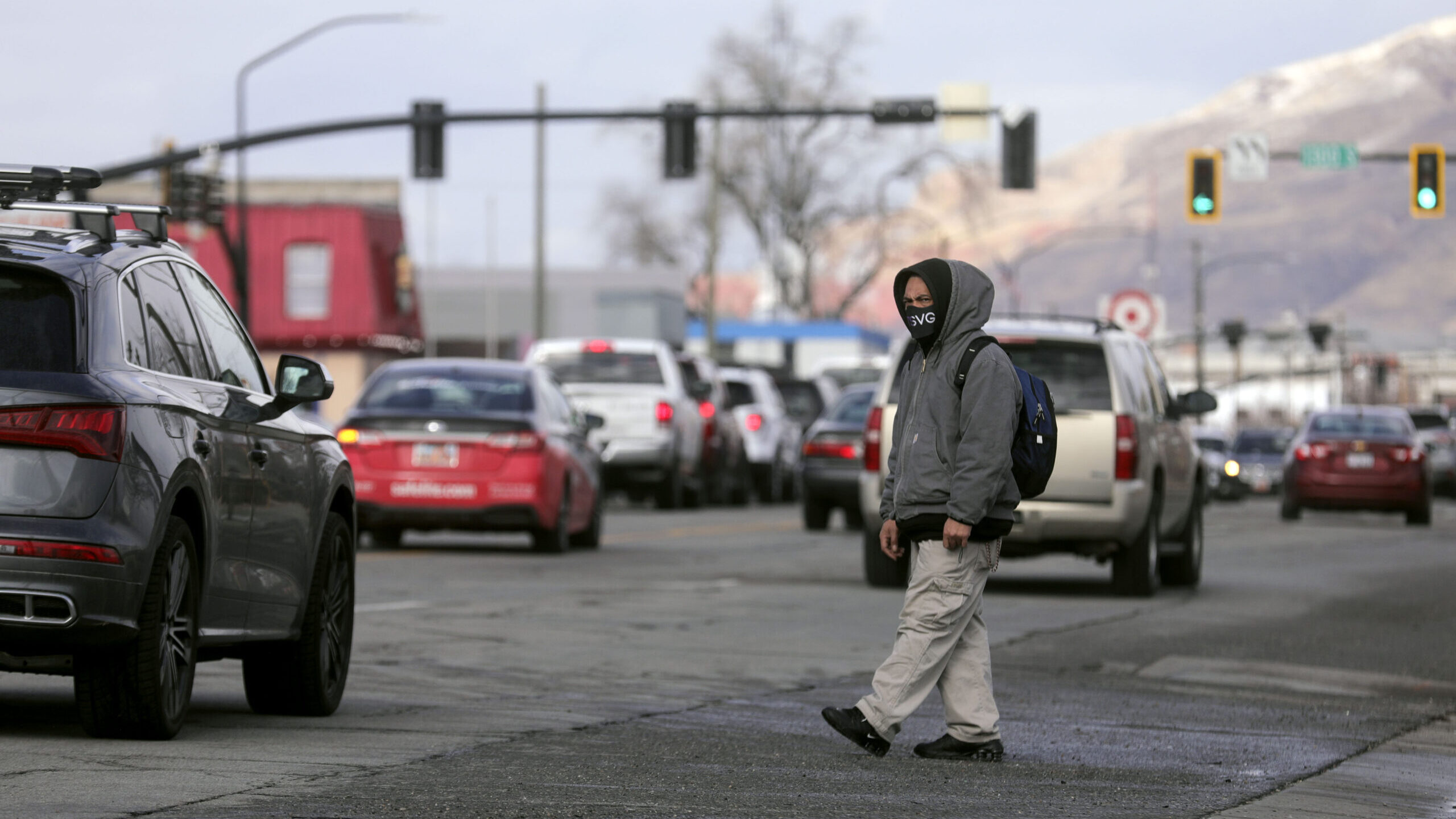 A man looks for a break in traffic as he crosses 300 West at a busy pedestrian area between Walmart...
