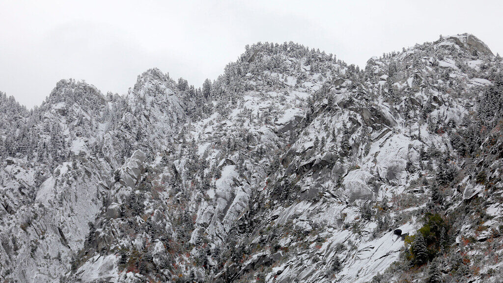 Snow covers the mountains during an early season snowstorm in Little Cottonwood Canyon on Thursday,...