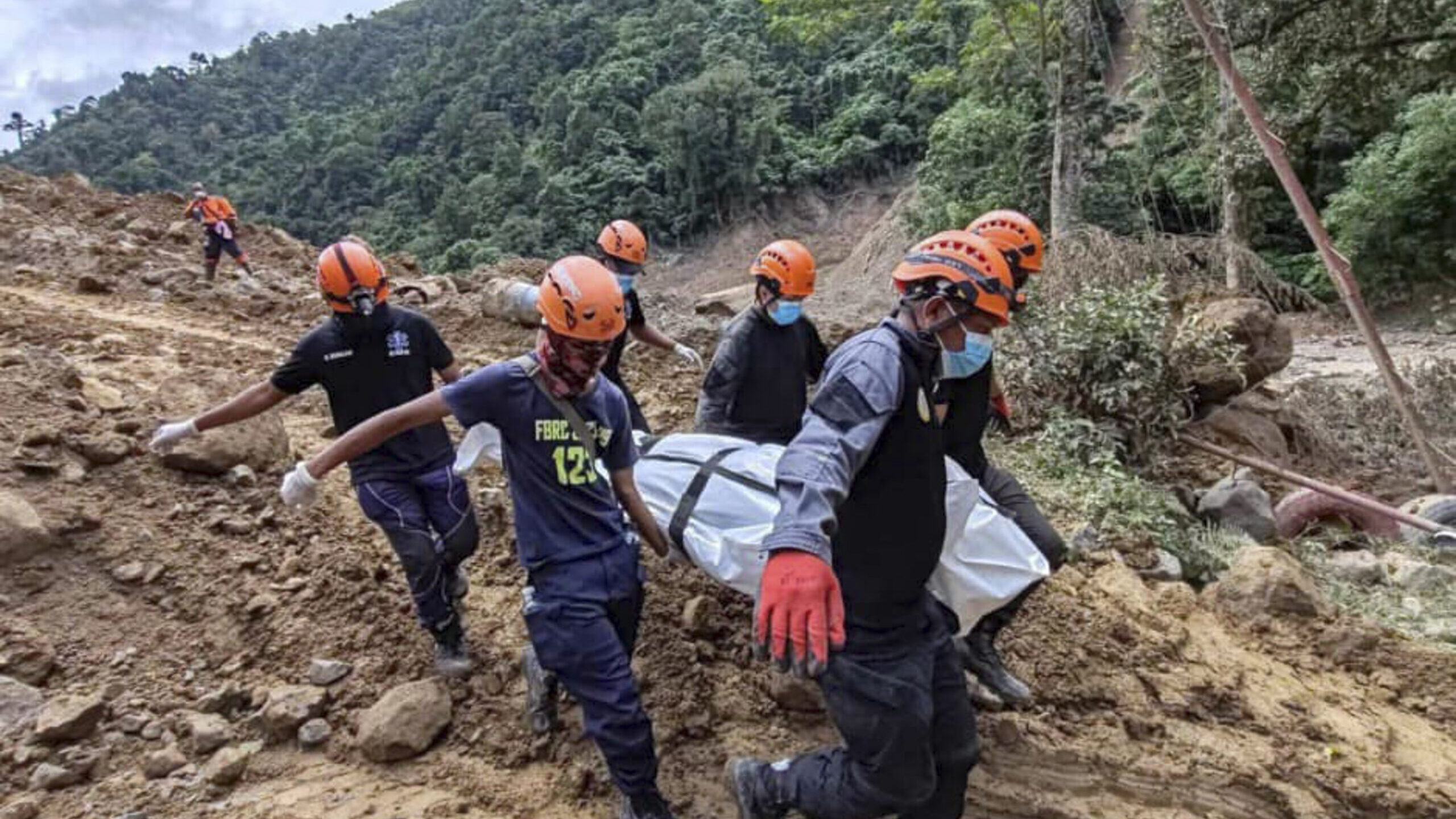 In this Feb. 9, 2024 handout photo from Municipality of Monkayo, rescuers carry a body they recover...