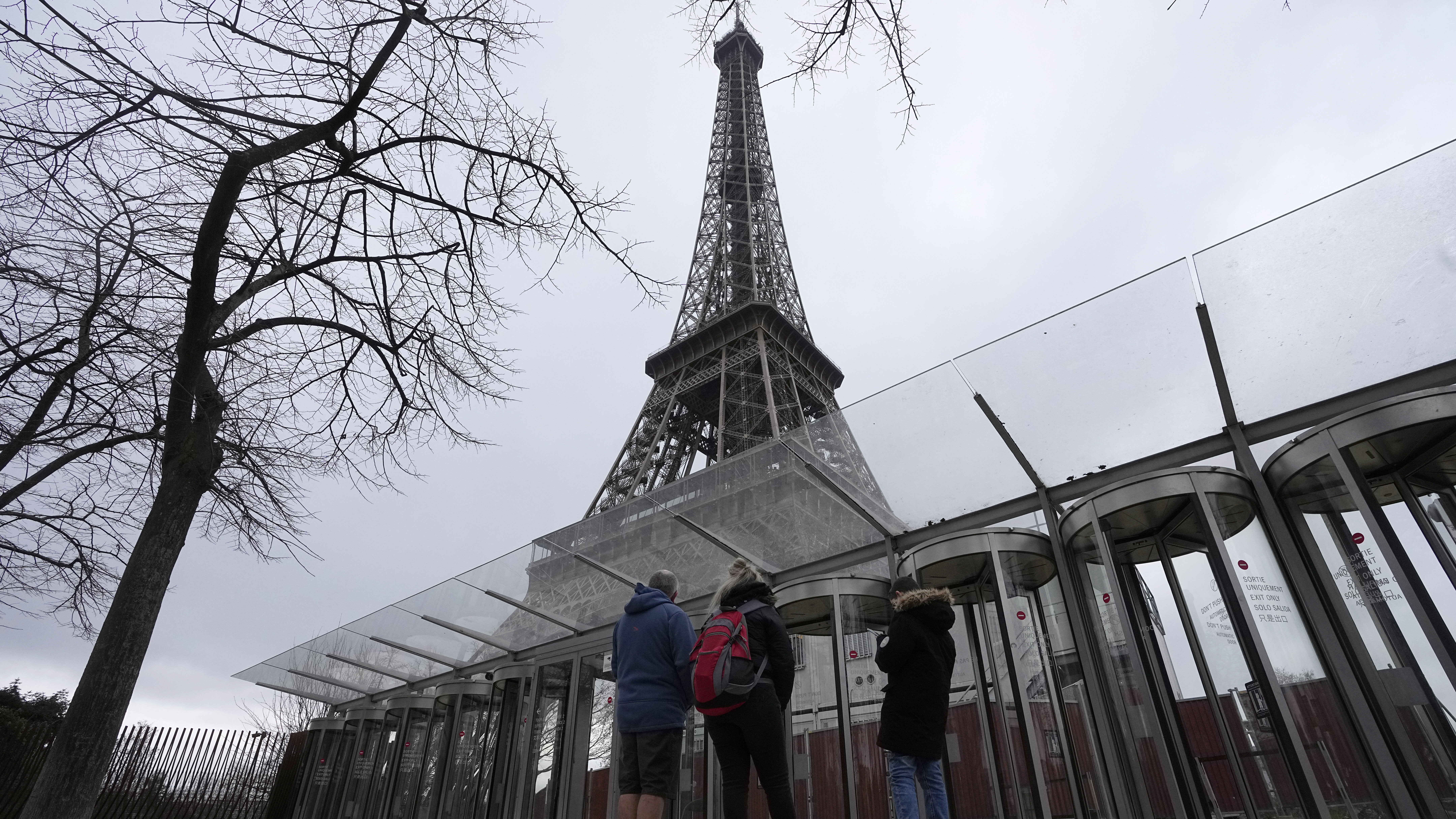 Visitors stand at the closed gates leading to the Eiffel Tower, Tuesday, Feb. 20, 2024 in Paris....