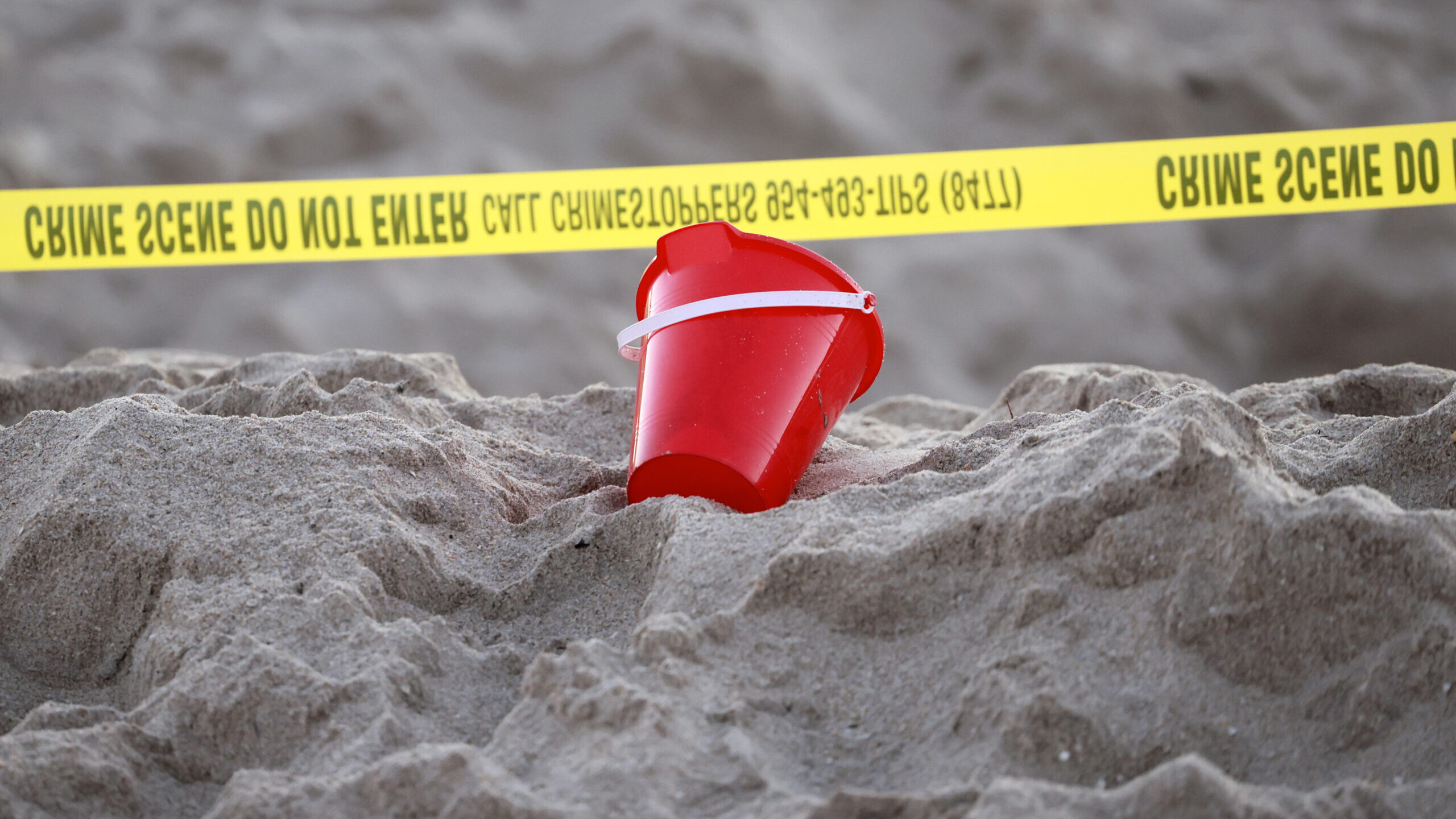 A pail rests next to caution tape on a beach in Lauderdale-by-the-Sea, Fla., on Tuesday, Feb. 20, 2...