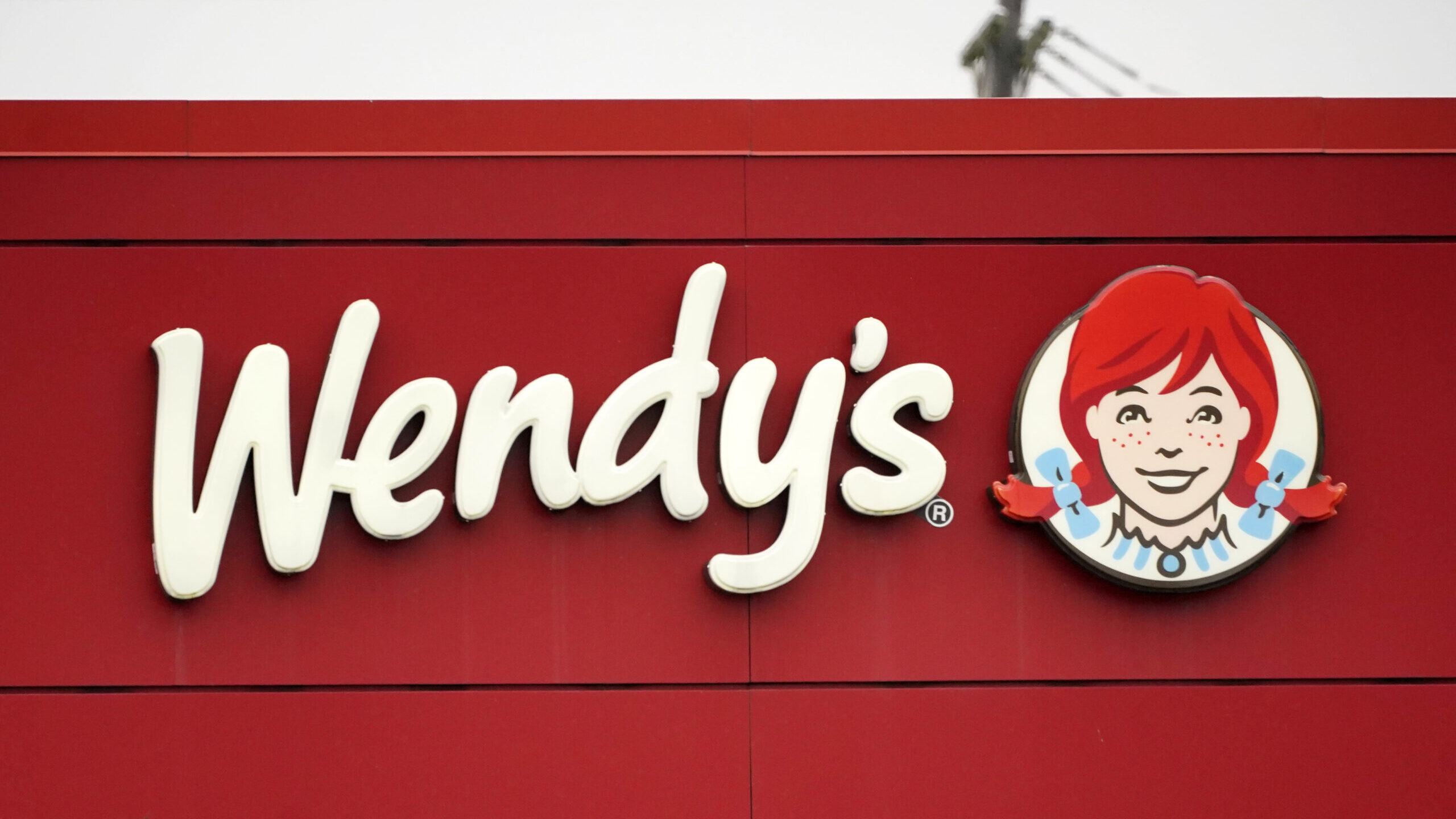The Wendy's logo appears over a red background...