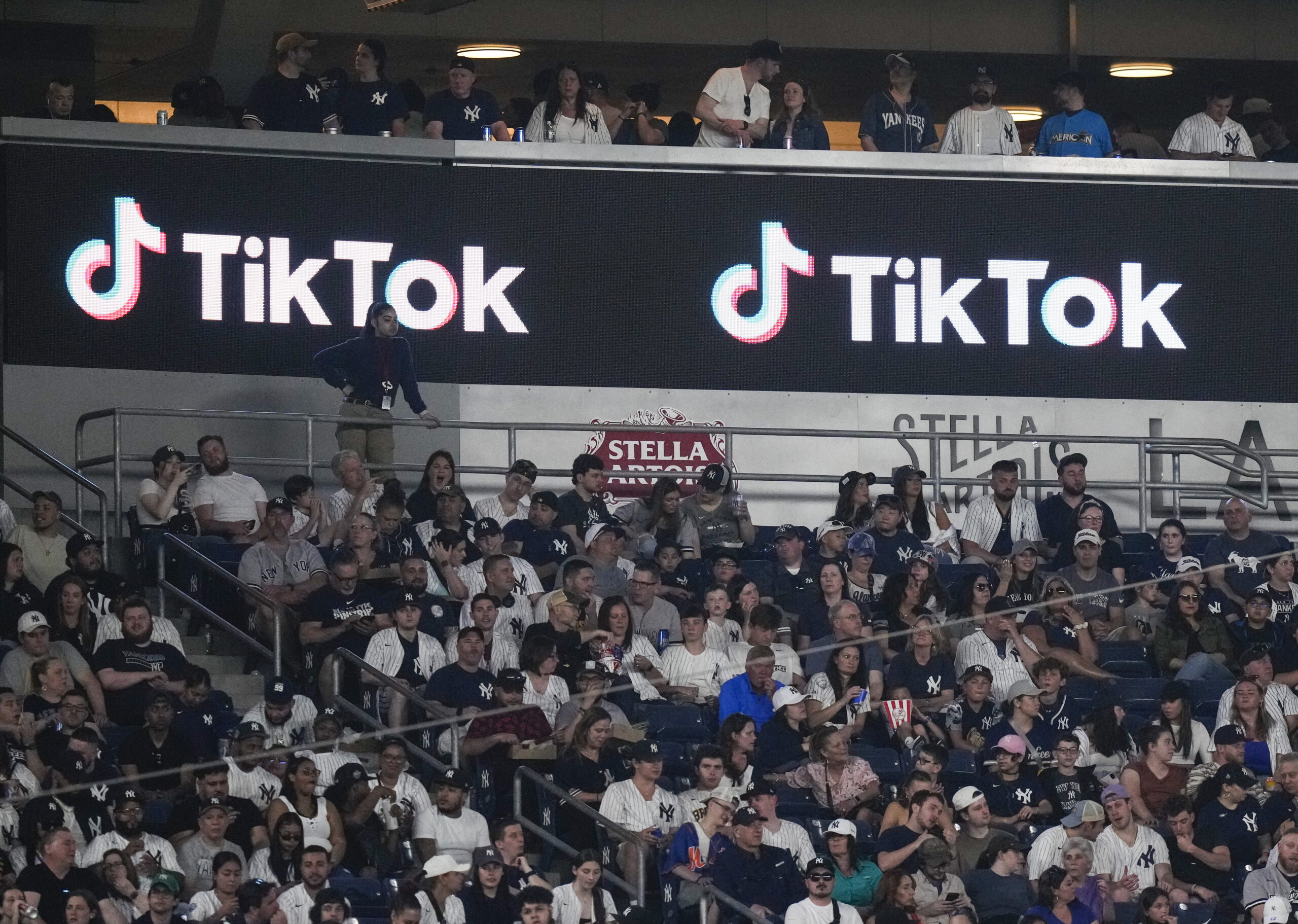 FILE - Fans sit under a TikTok ad at a baseball game at Yankee Stadium, April 14, 2023, in New York...