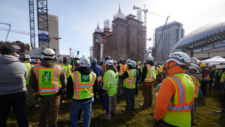 Construction team members gather Tuesday, February 13, 2024, to sign some of the final reinforcing ...